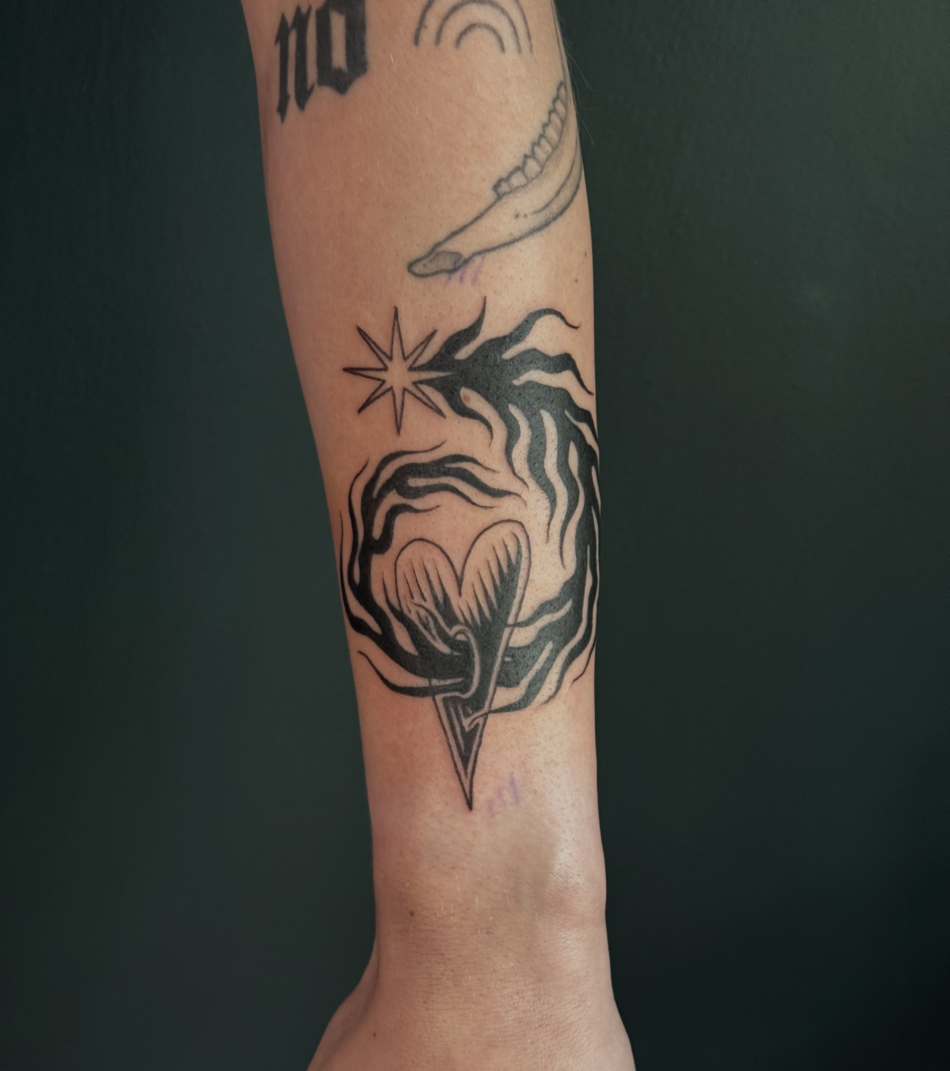 Flame and heart black and grey tattoo on the forearm by Paul DeVay