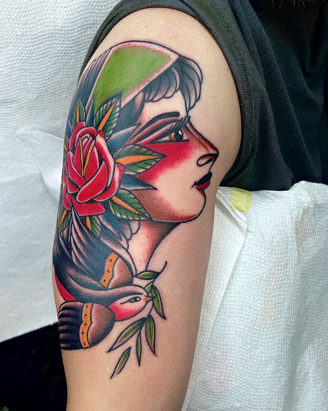 Woman with rose American traditional tattoo on the upper arm by Massimiliano pennella