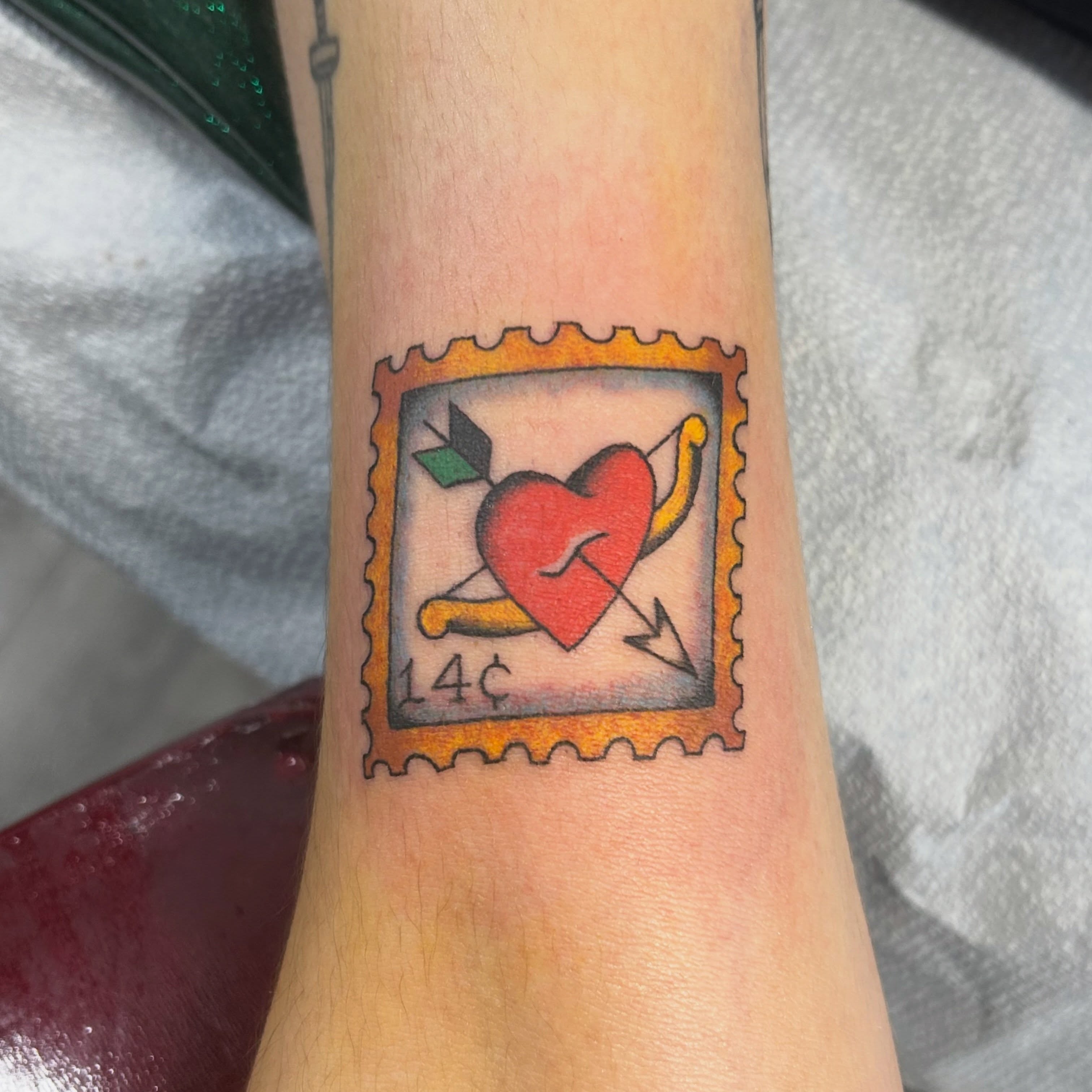 Heart with arrow American traditional tattoo on the forearm by Tawni Bender
