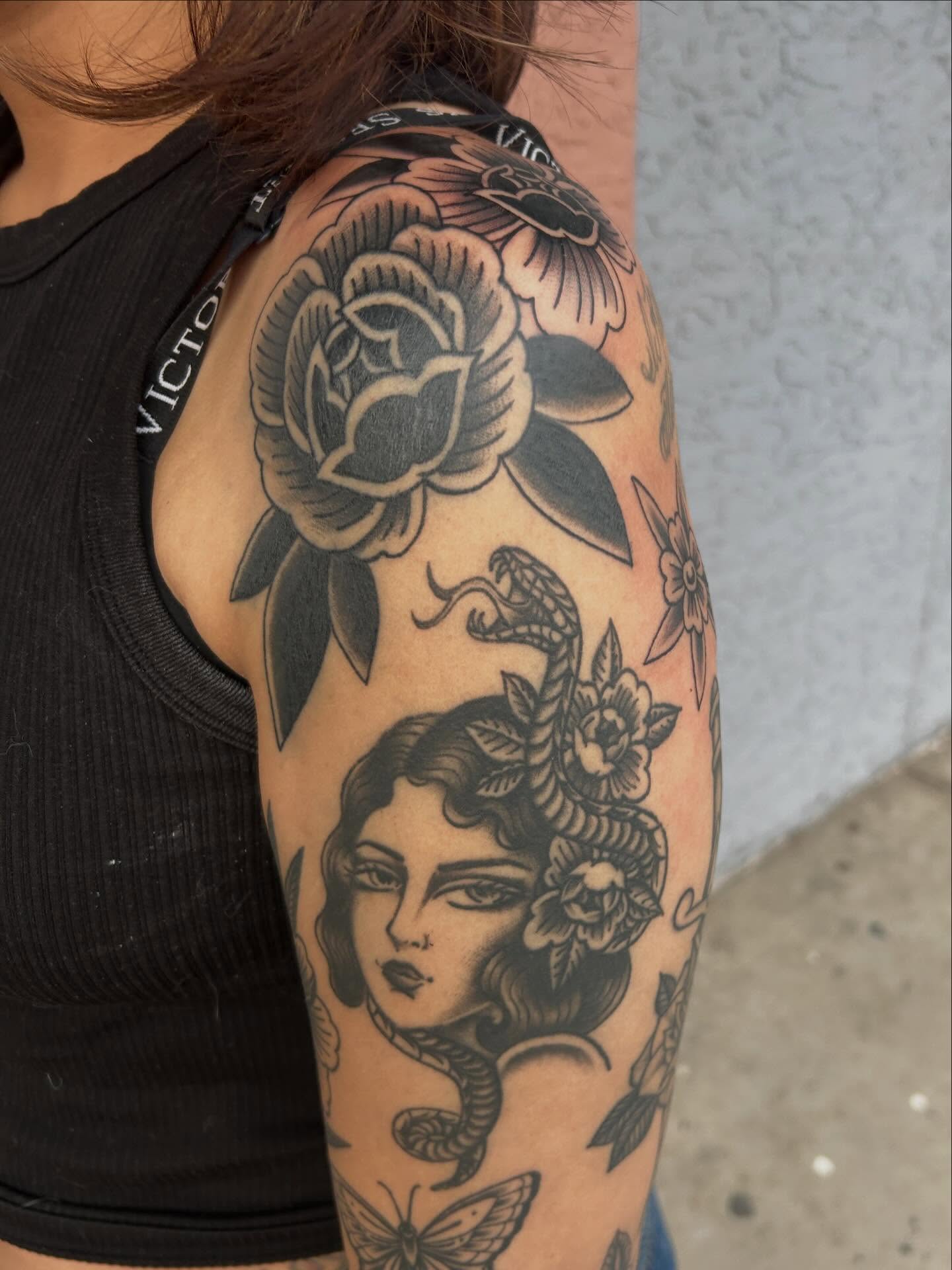 Woman's head with snake American traditional tattoo on the upper arm by Janelle McCarthy
