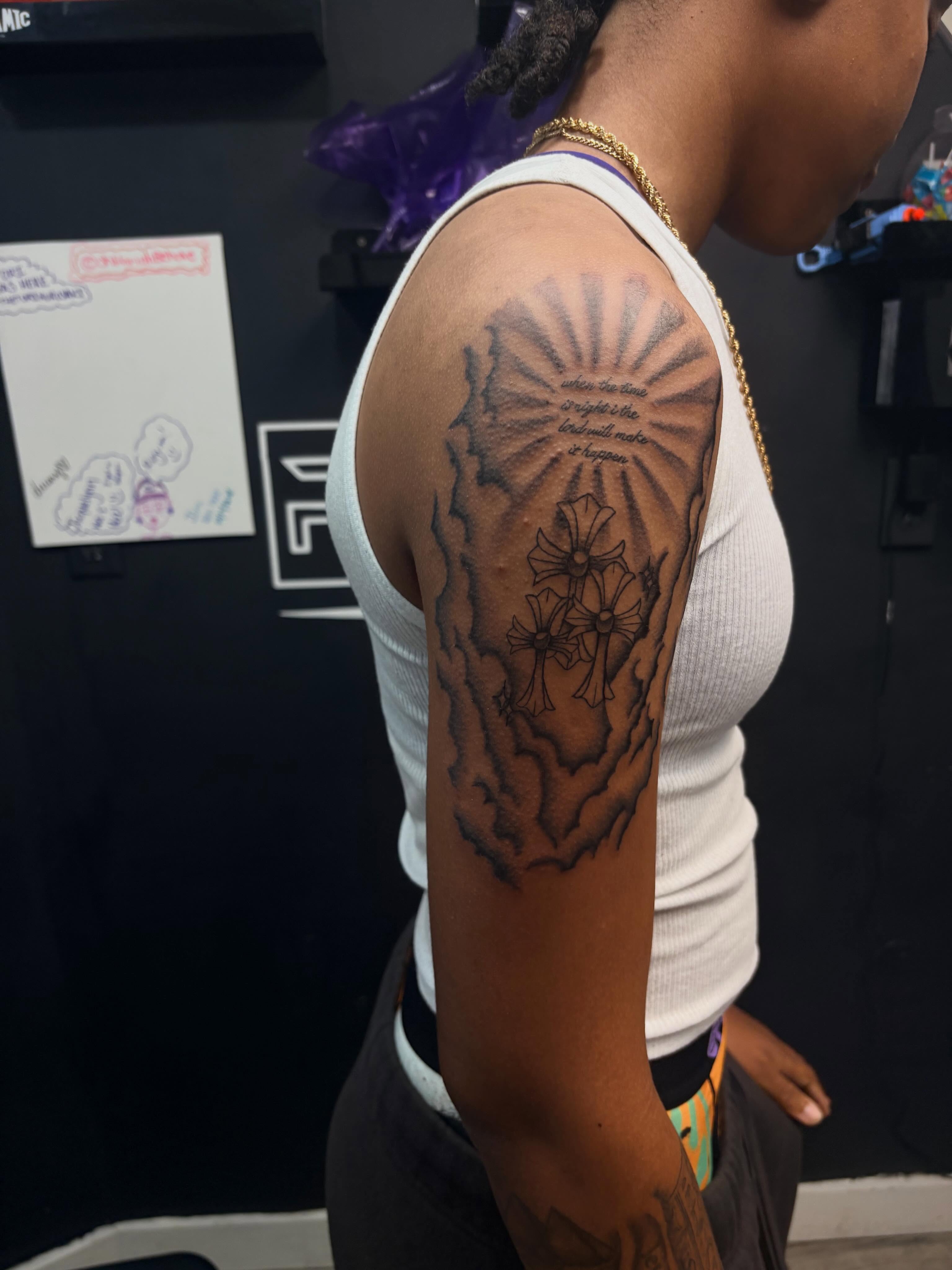 Crosses and floral black and grey tattoo on the upper arm by 𝓚𝓪𝓻𝓶𝓪💫
