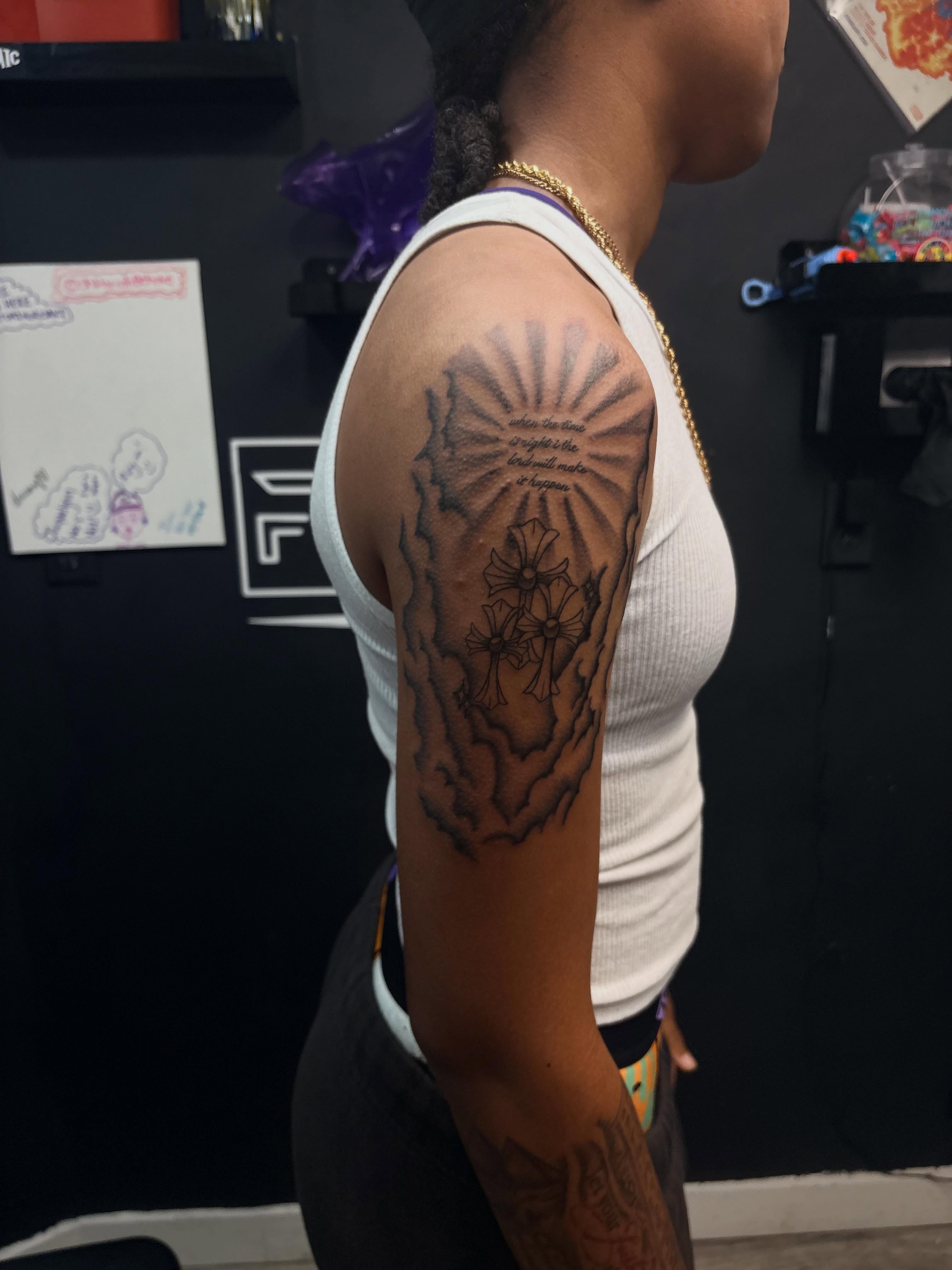 Flowers and sunburst black and grey tattoo on the upper arm by 𝓚𝓪𝓻𝓶𝓪💫