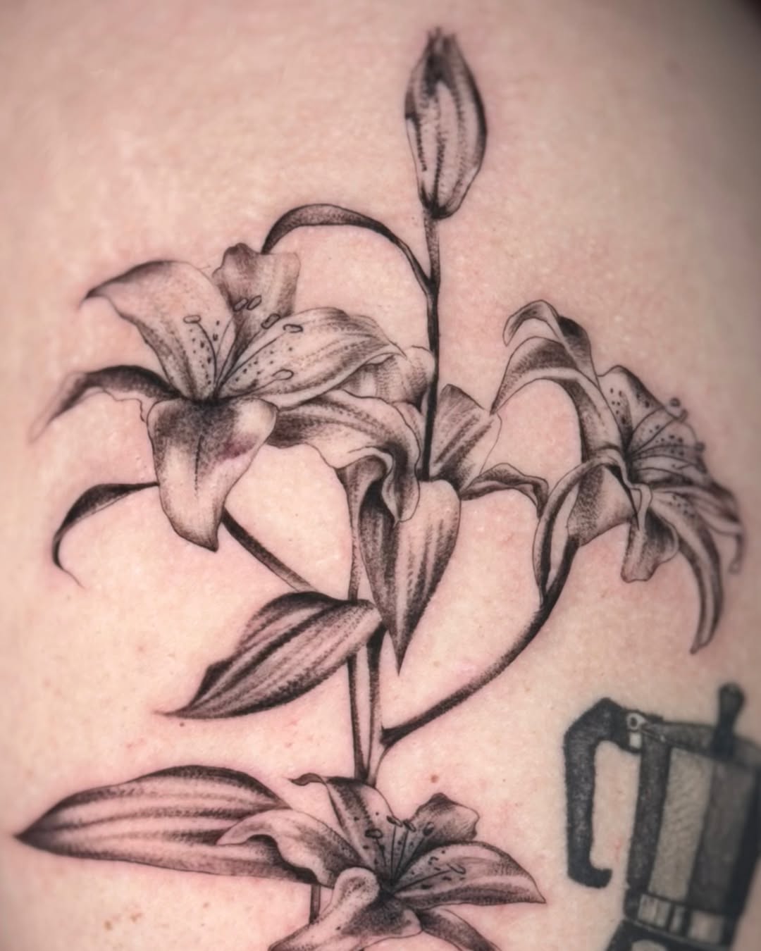 Lilies black and grey tattoo on the shoulder by Mariana; Fine Line Tattoo Artist