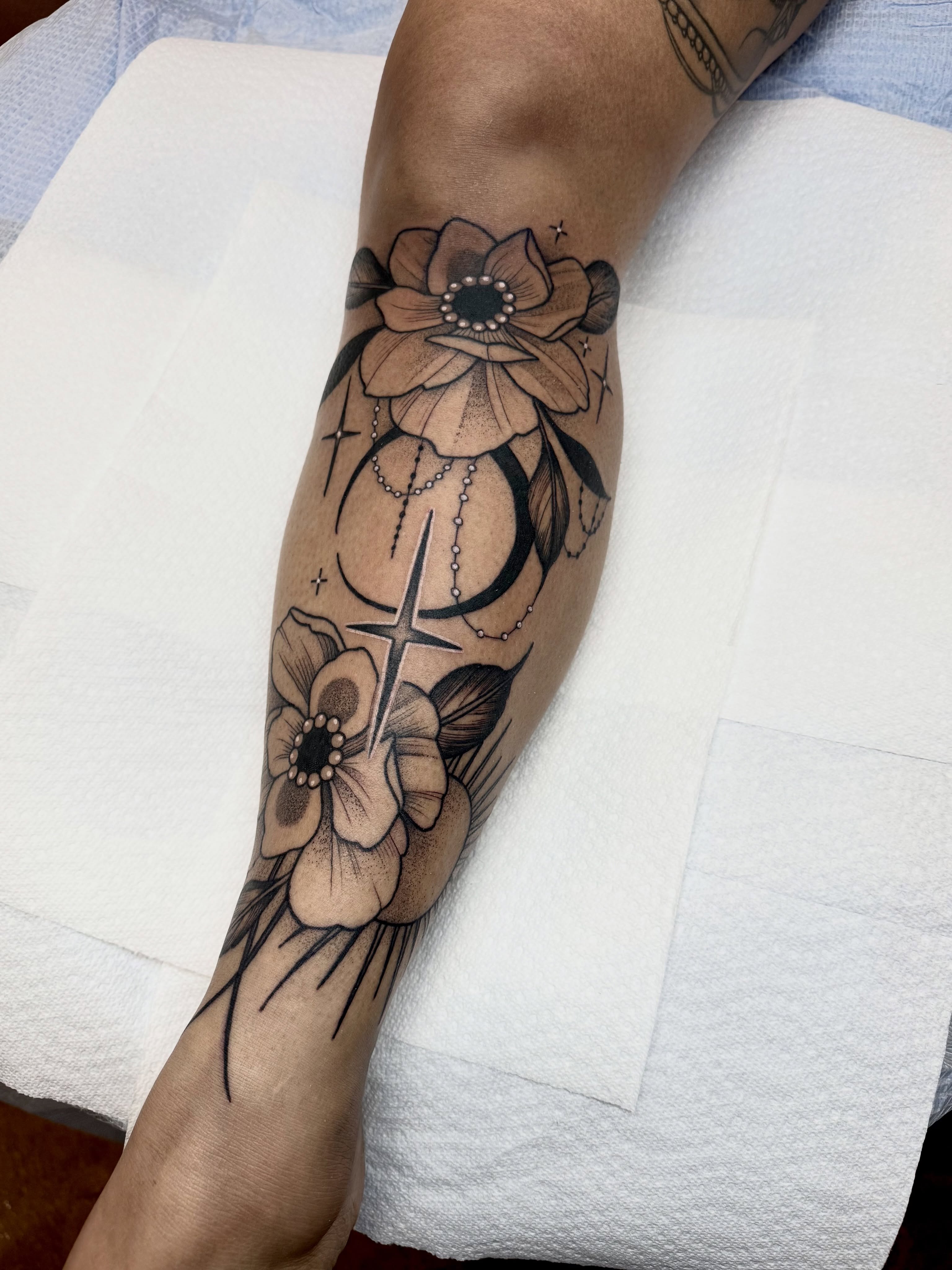 Flowers and celestial symbols dotwork tattoo on the forearm by ⚡️ Krissy Fabis ⚡️