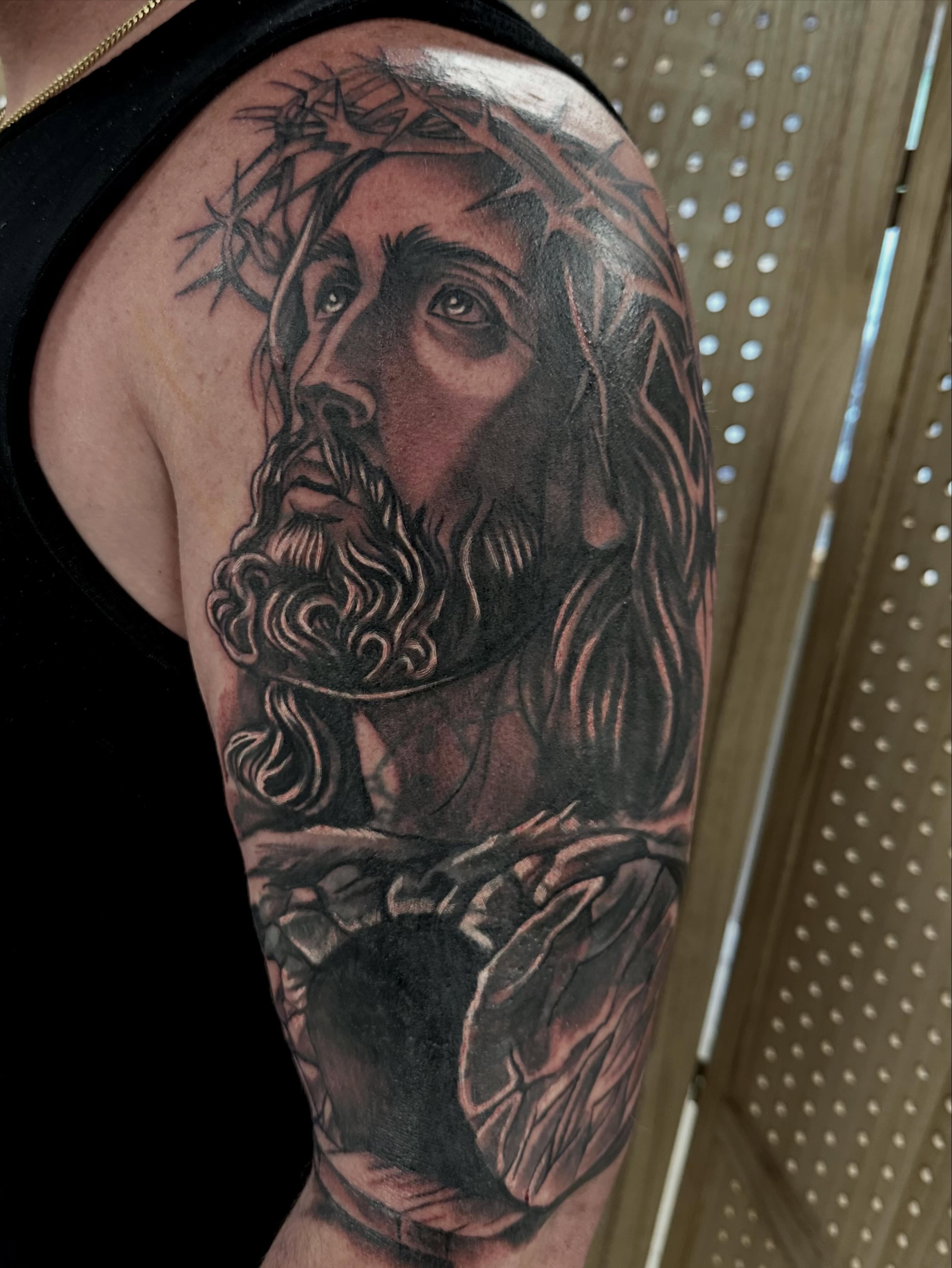 Religious figure realism tattoo on the upper arm by Vincent Merys