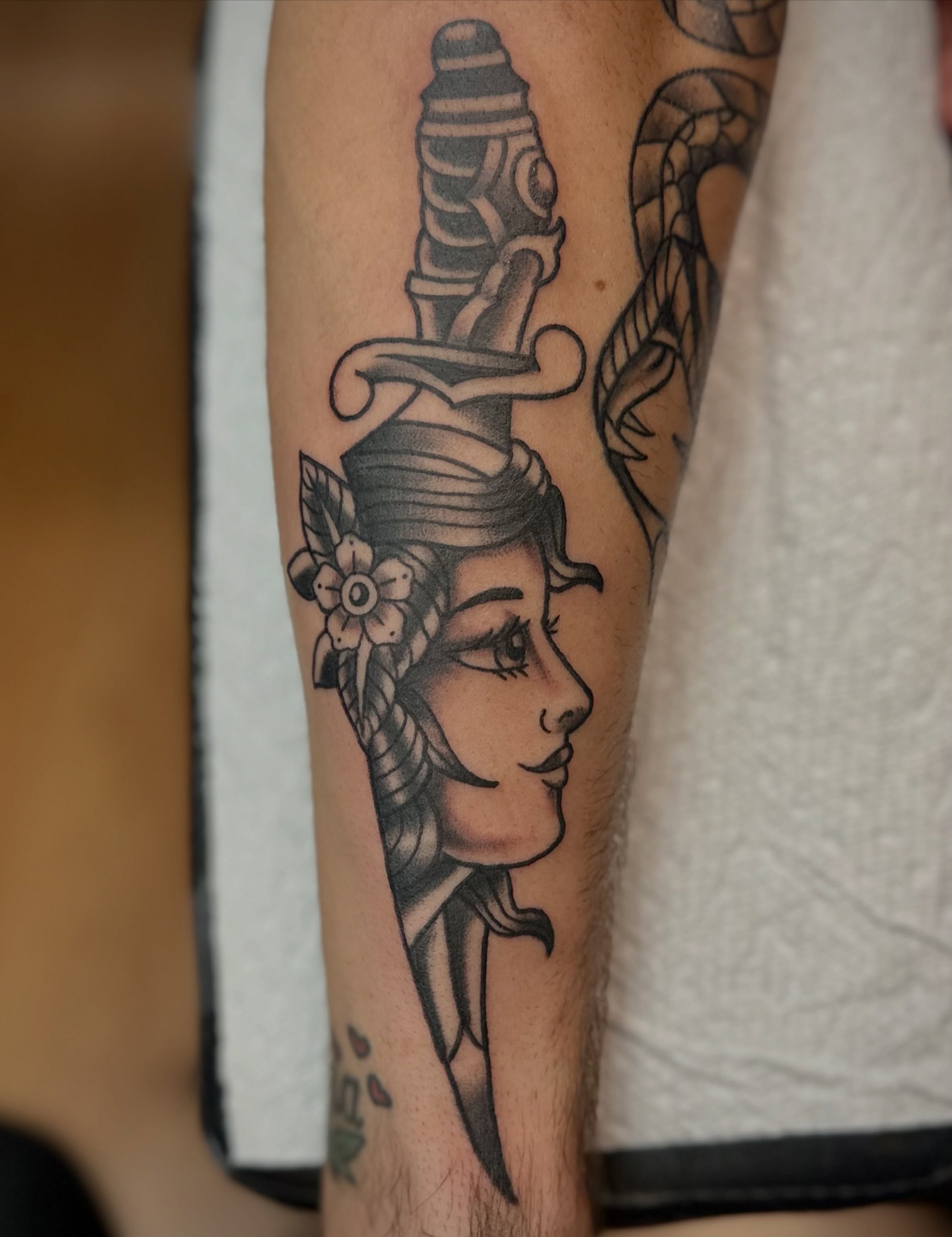 Woman with dagger American traditional tattoo on the forearm by Josh Robinson