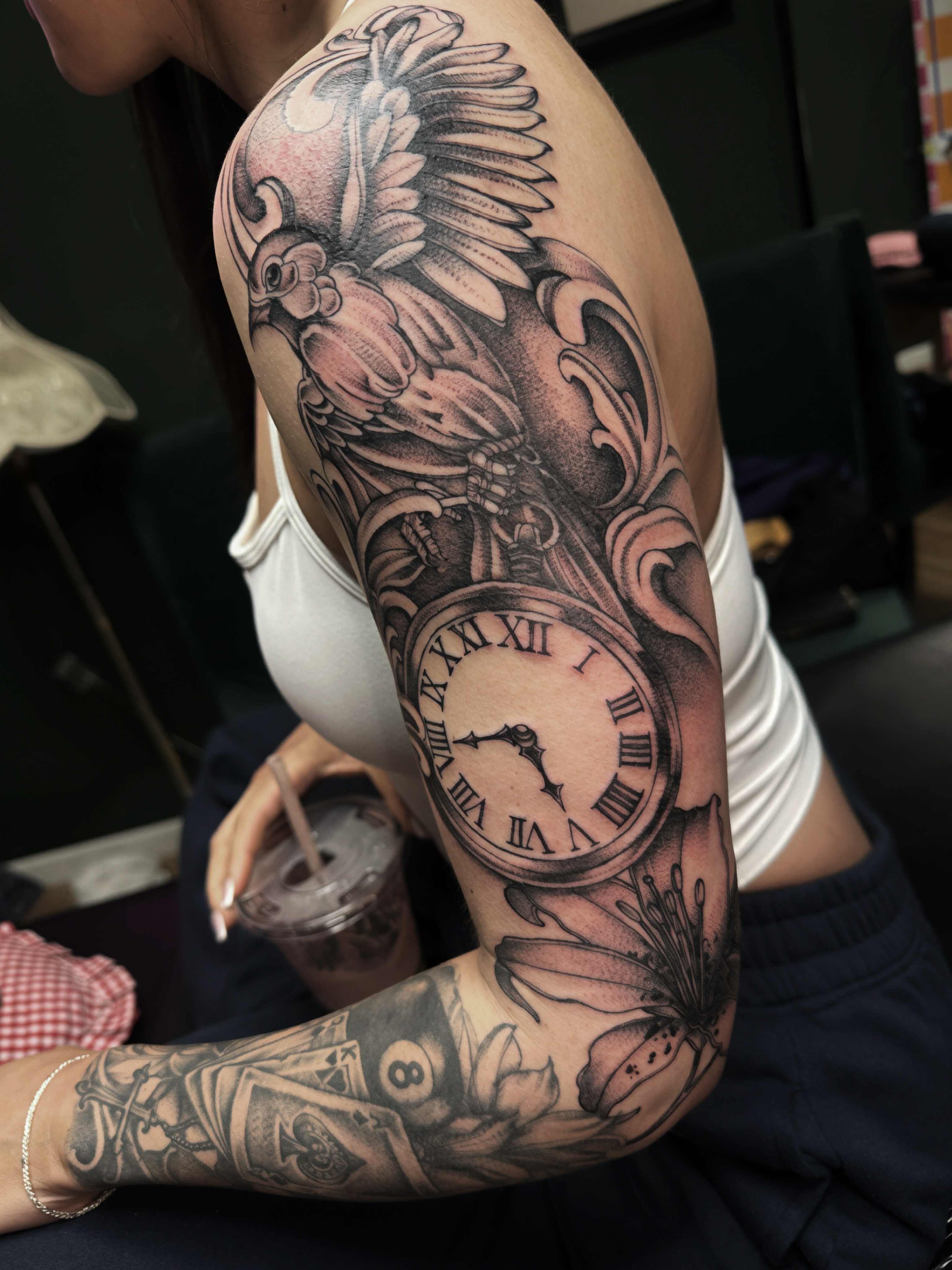 Clock and bird realism tattoo on the upper arm by Saffron Florea, Tiffin, Ohio