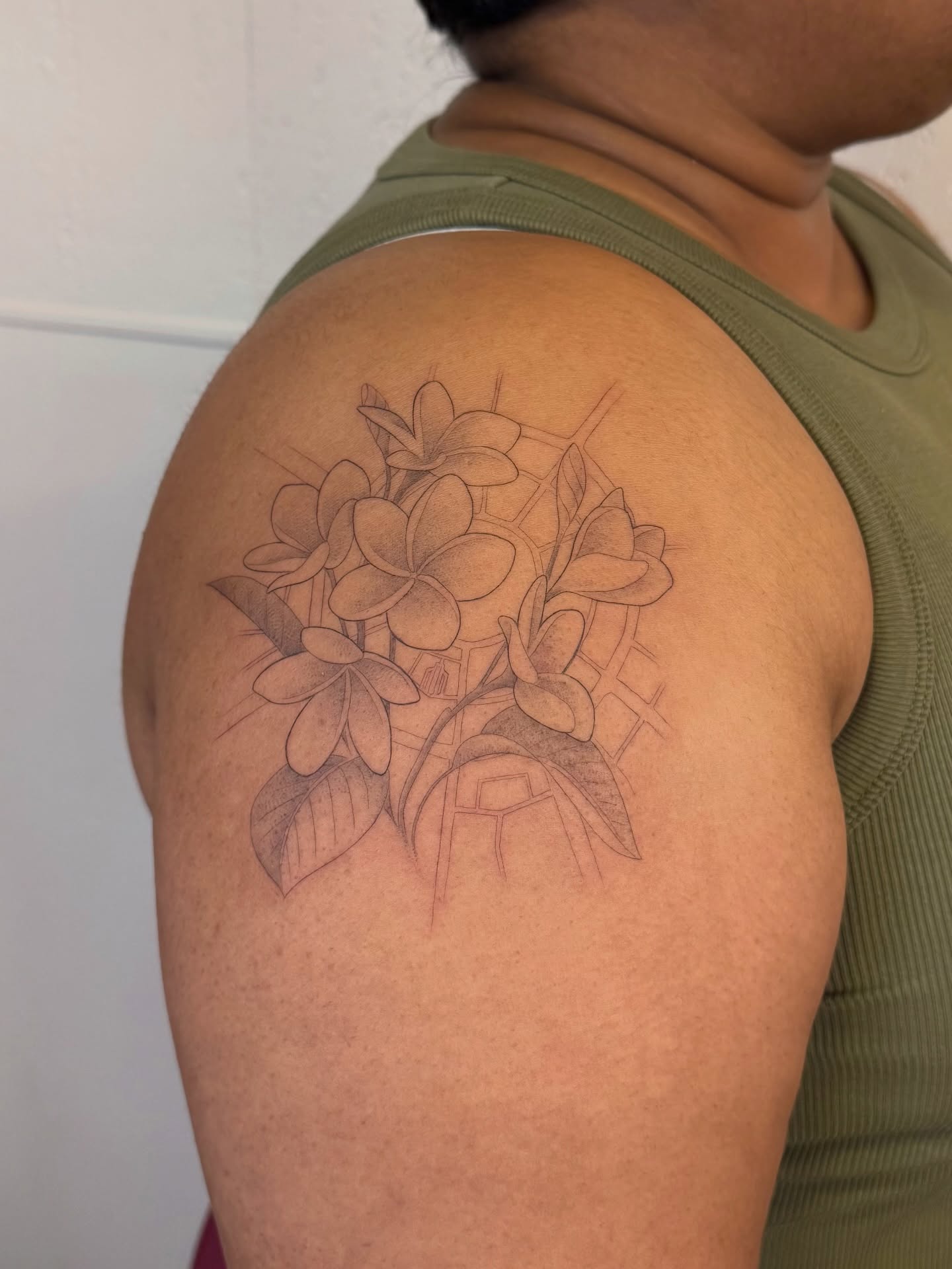 Plumeria flowers black and grey tattoo on the shoulder by Justin Turkus