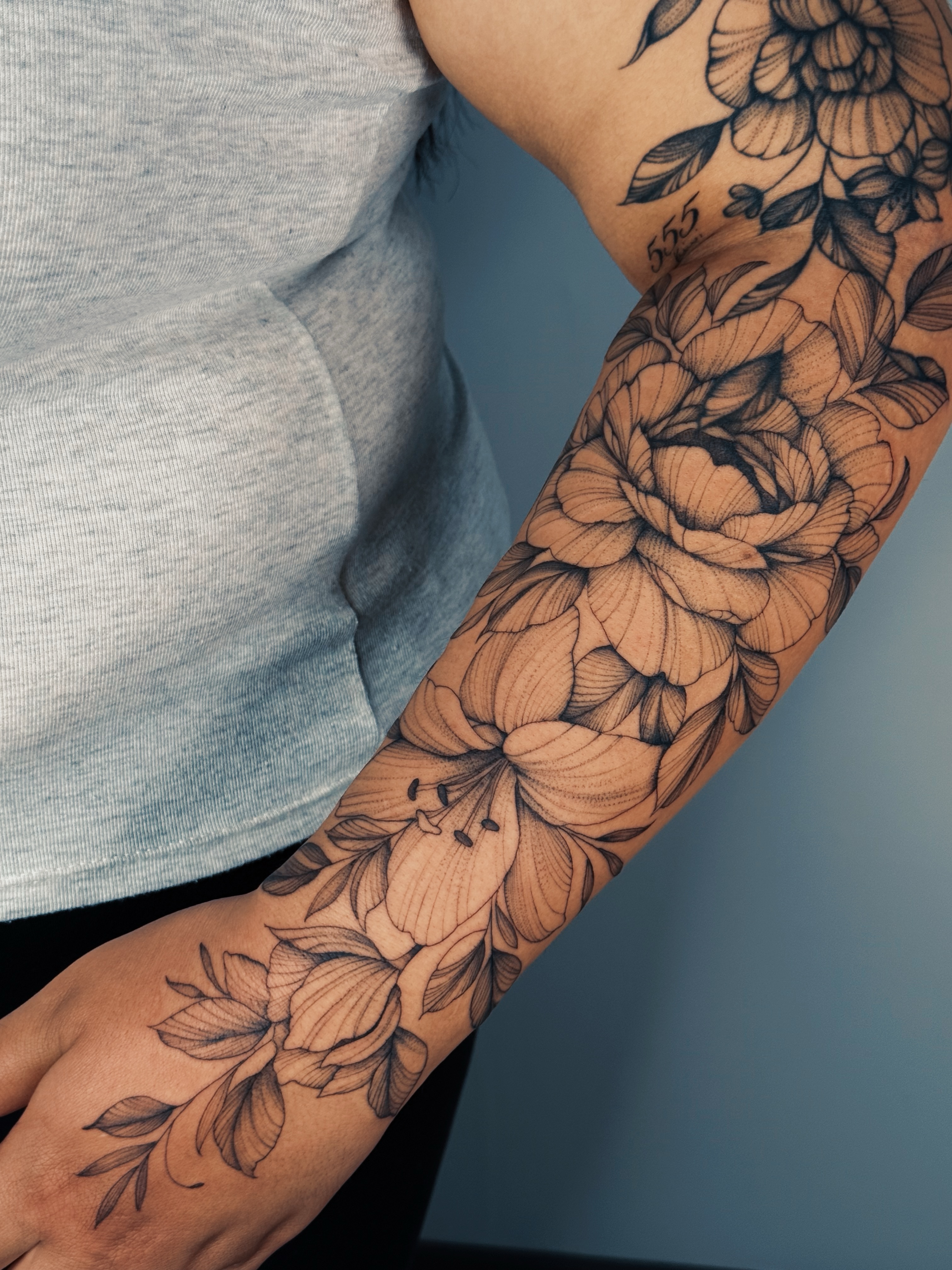 Floral bouquet black and grey tattoo on the forearm by Olha Tytarenko