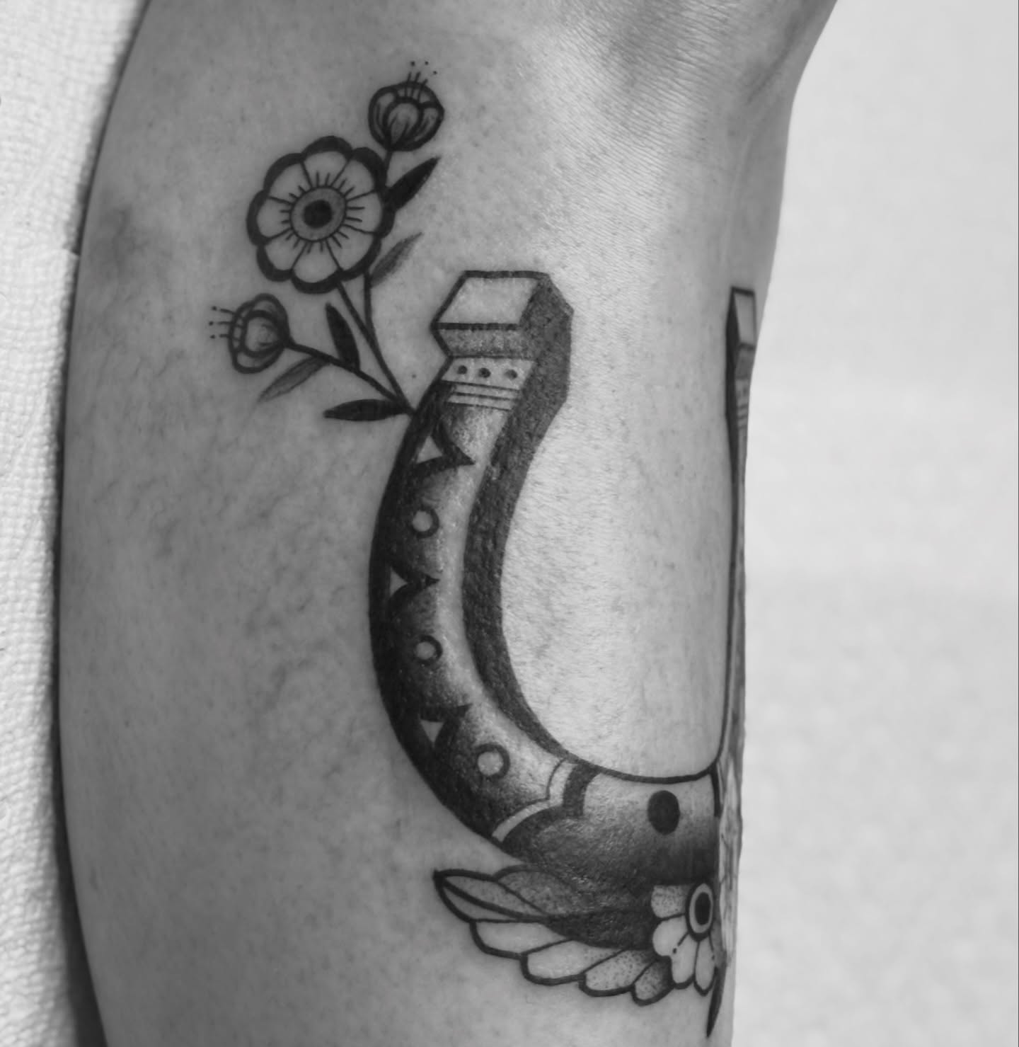 Horseshoe and flowers American traditional tattoo on the forearm by MJ Saunders