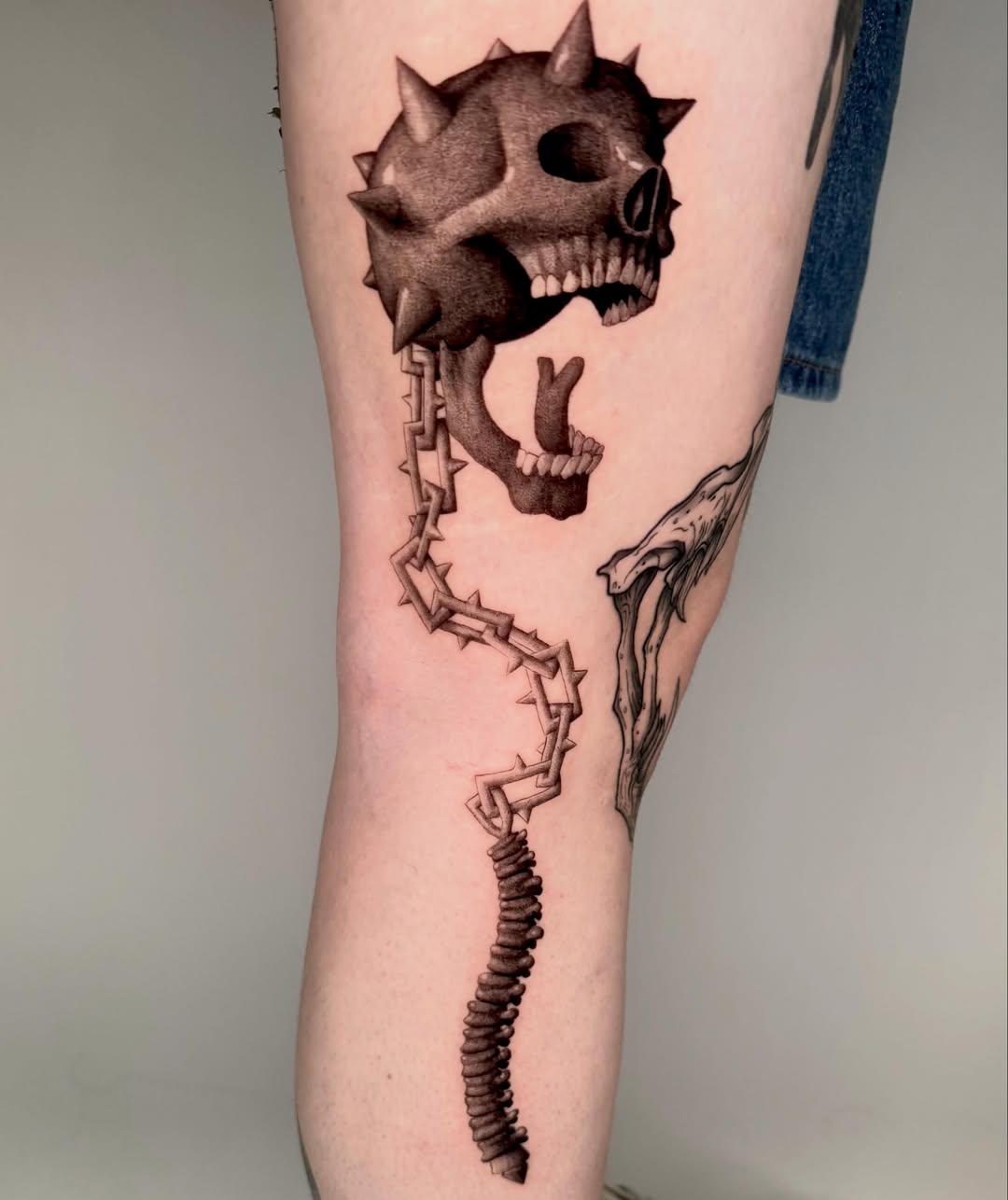 Spiked skull realism tattoo on the forearm by Andrew Flatts