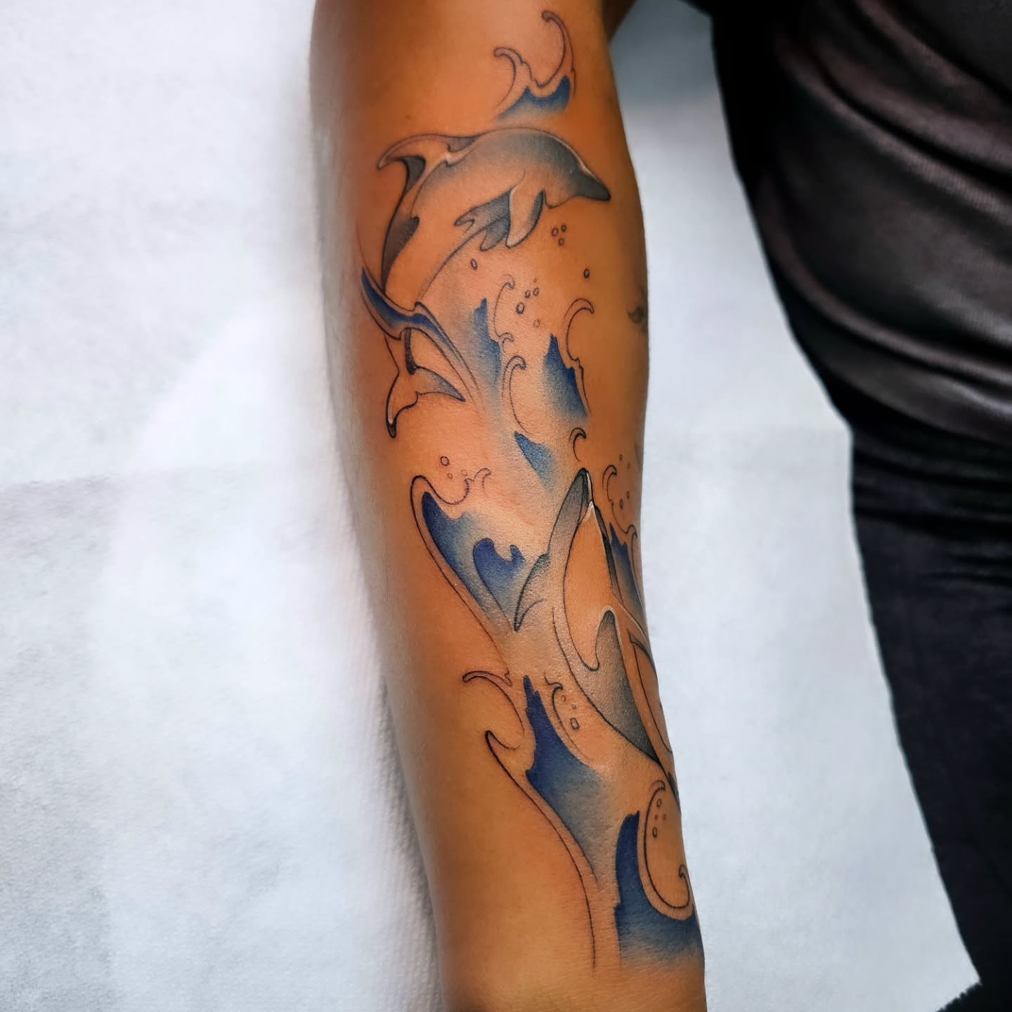Dolphins new school tattoo on the forearm by Adriannah Esparza