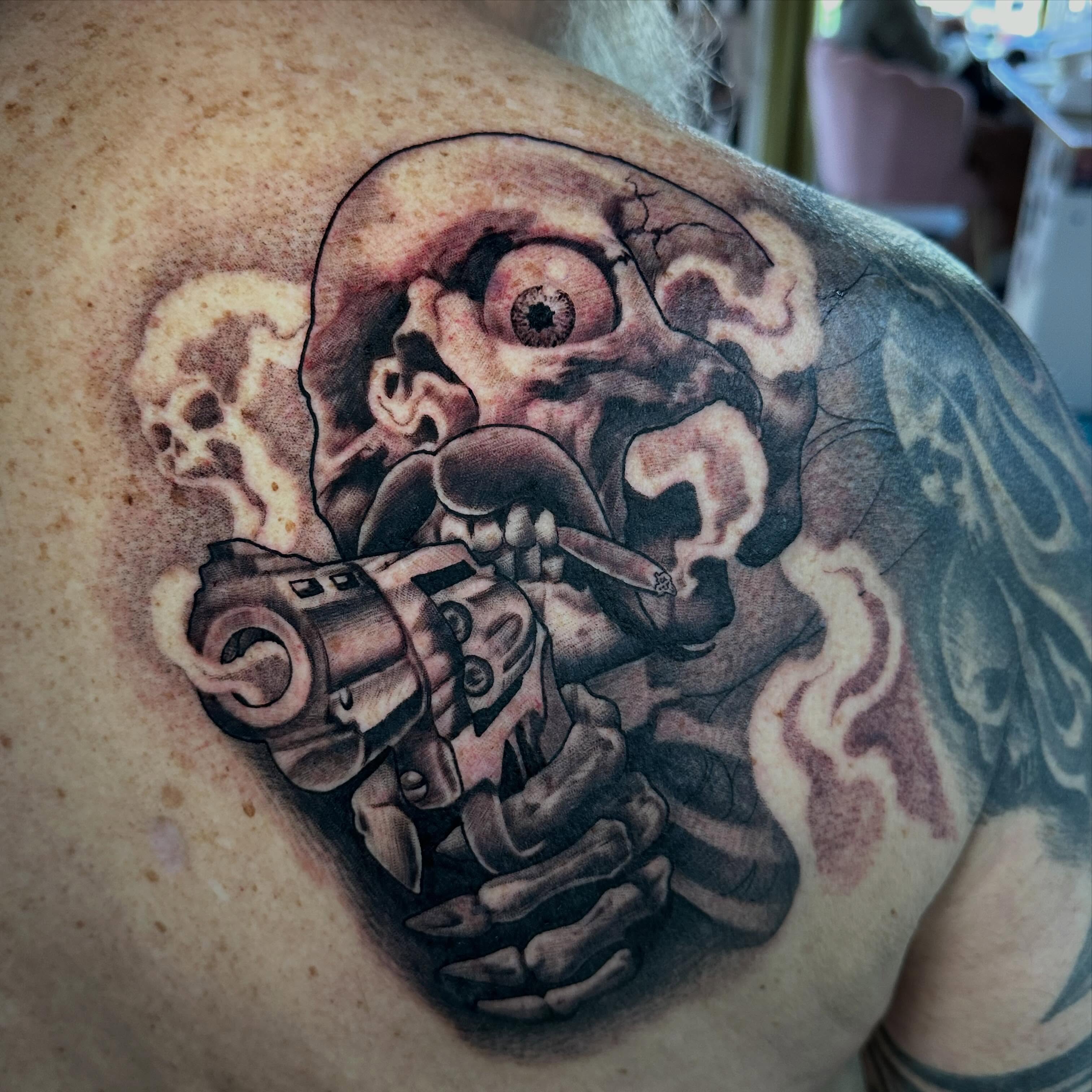 Smoking skull with grenade dark realism tattoo on the shoulder by Dustin Clark, Dayton, Ohio