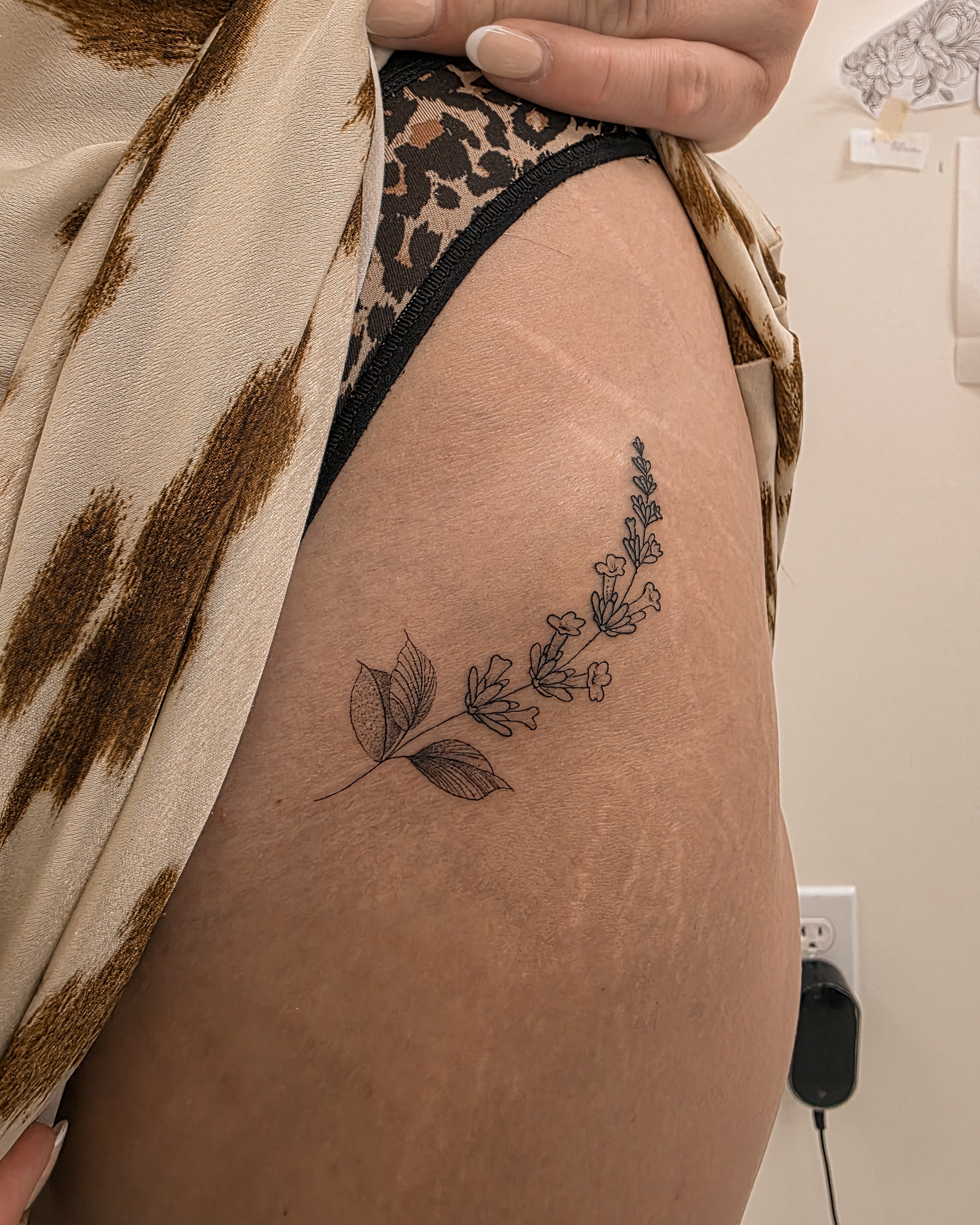 Floral arrangement black and grey tattoo on the thigh by Richmond tattoo shop, Richmond, Texas