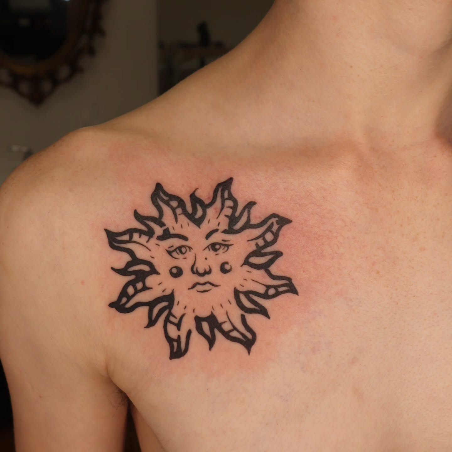 Sun black and grey tattoo on the shoulder by Veronika Lipchak