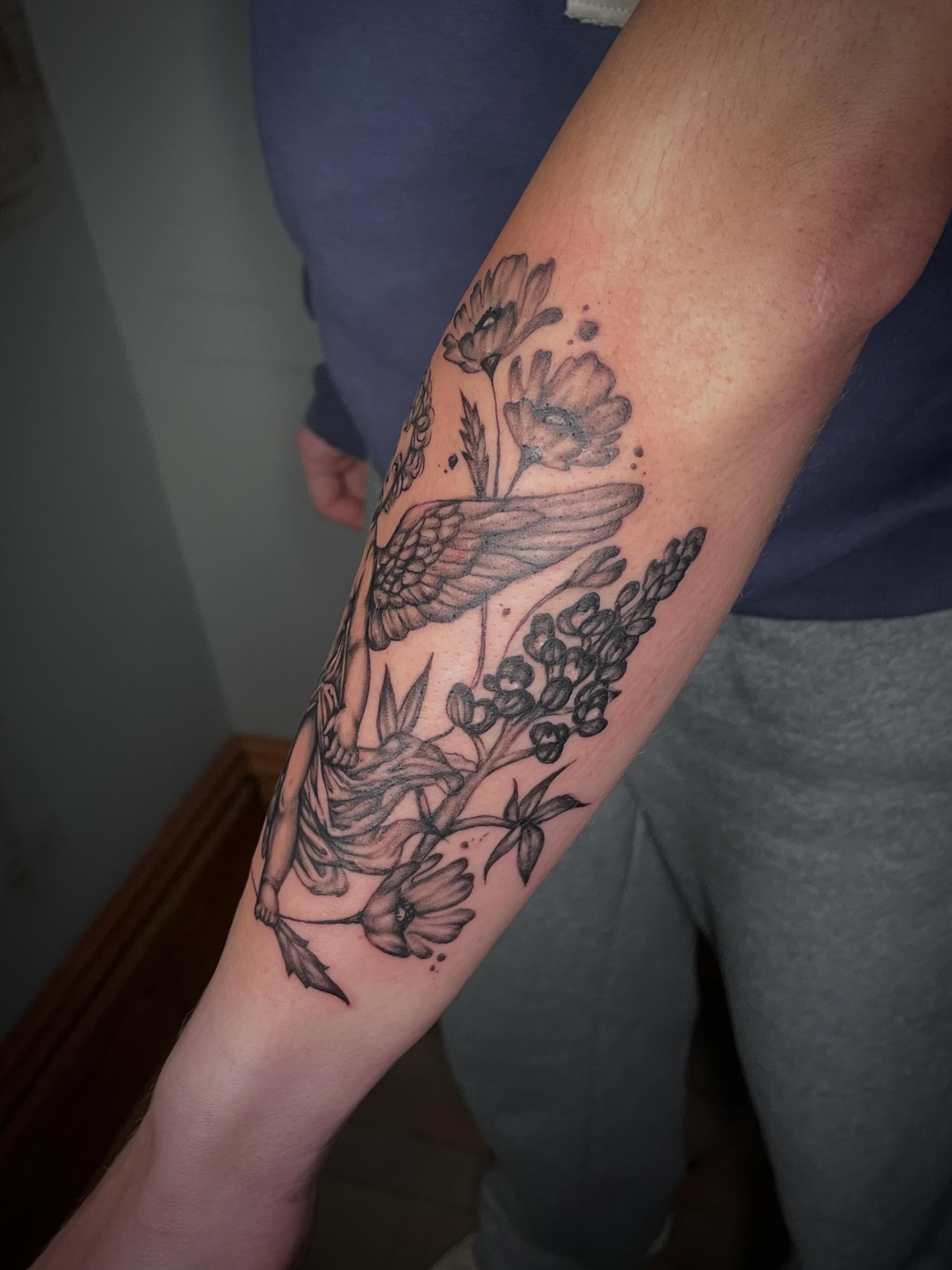Bird and flowers black and grey tattoo on the forearm by Hannah Copeskey