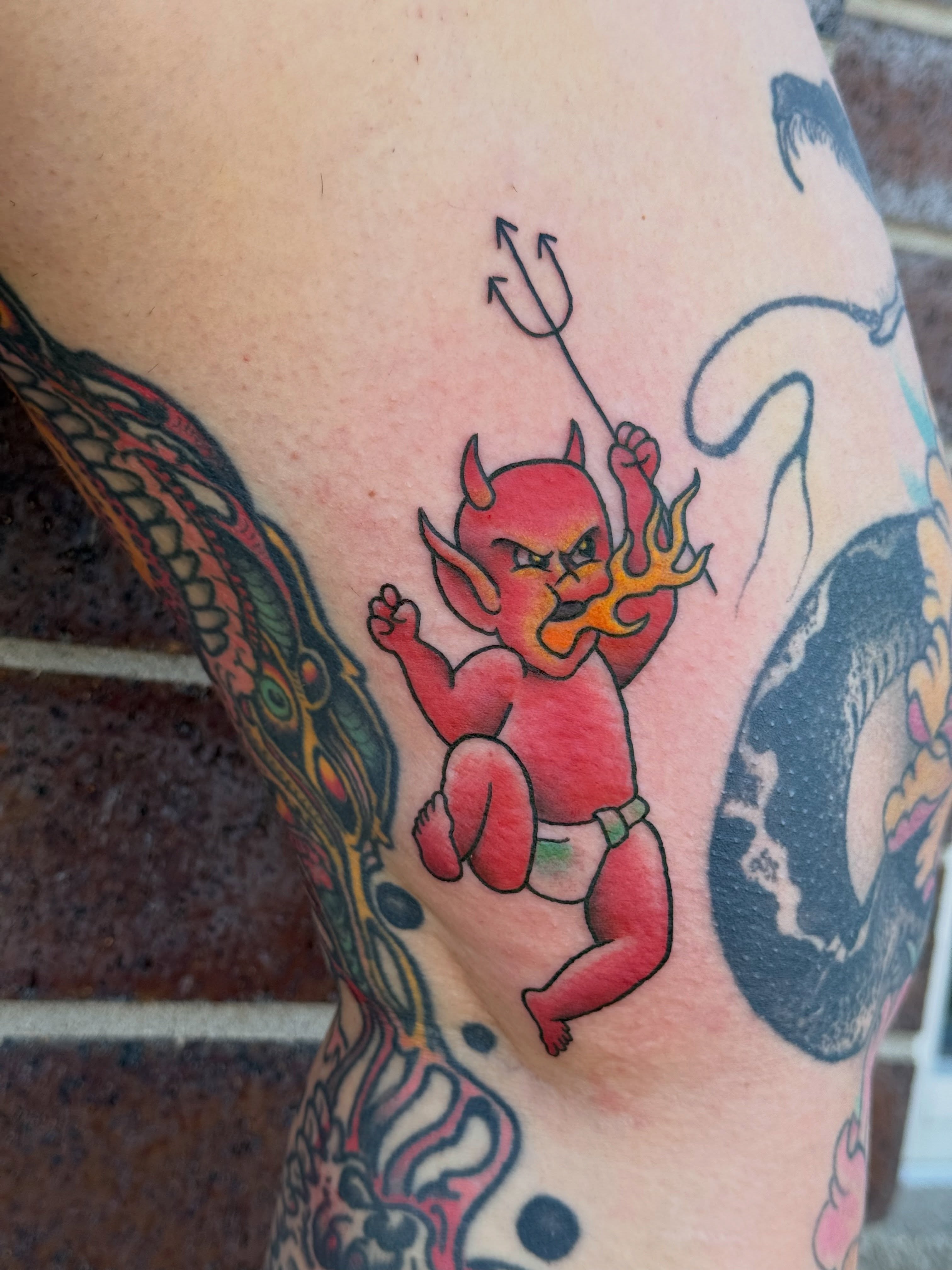 Red devil baby new school tattoo on the thigh by Kelsey Louis, Iowa City, Iowa