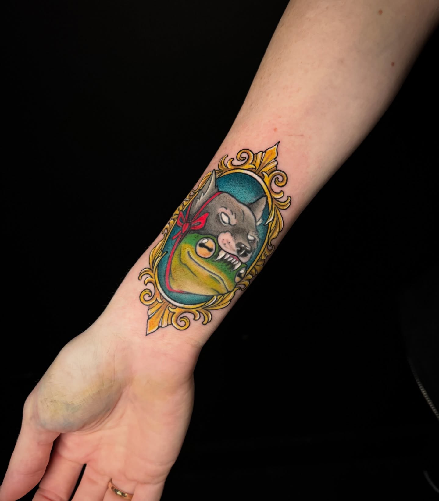 Wolf in frame American traditional tattoo on the forearm by Dee Florian