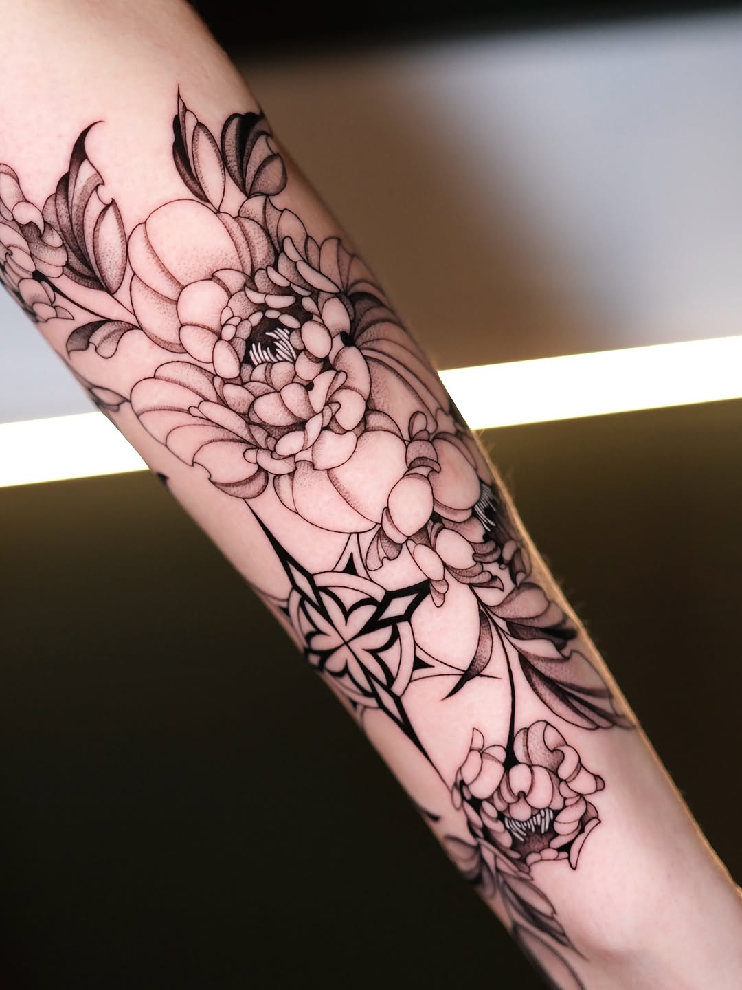 Peonies and geometric design dotwork tattoo on the forearm by IVY