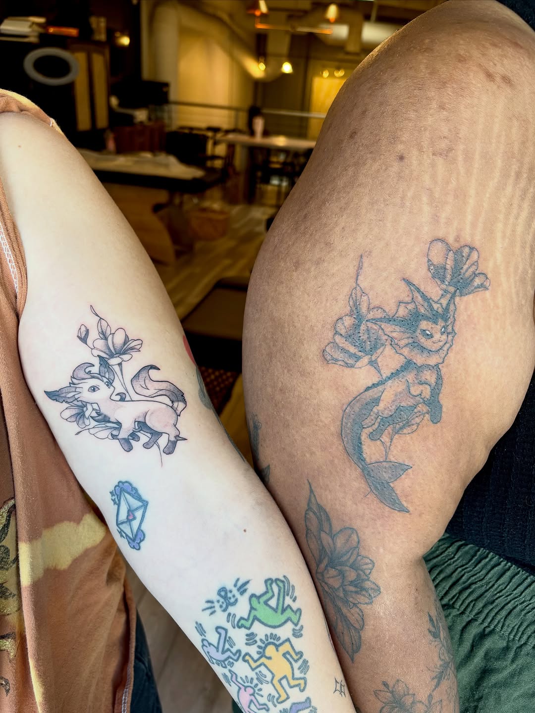 Eevee and Vaporeon new school tattoo on the upper arm by Bianca Cattapan