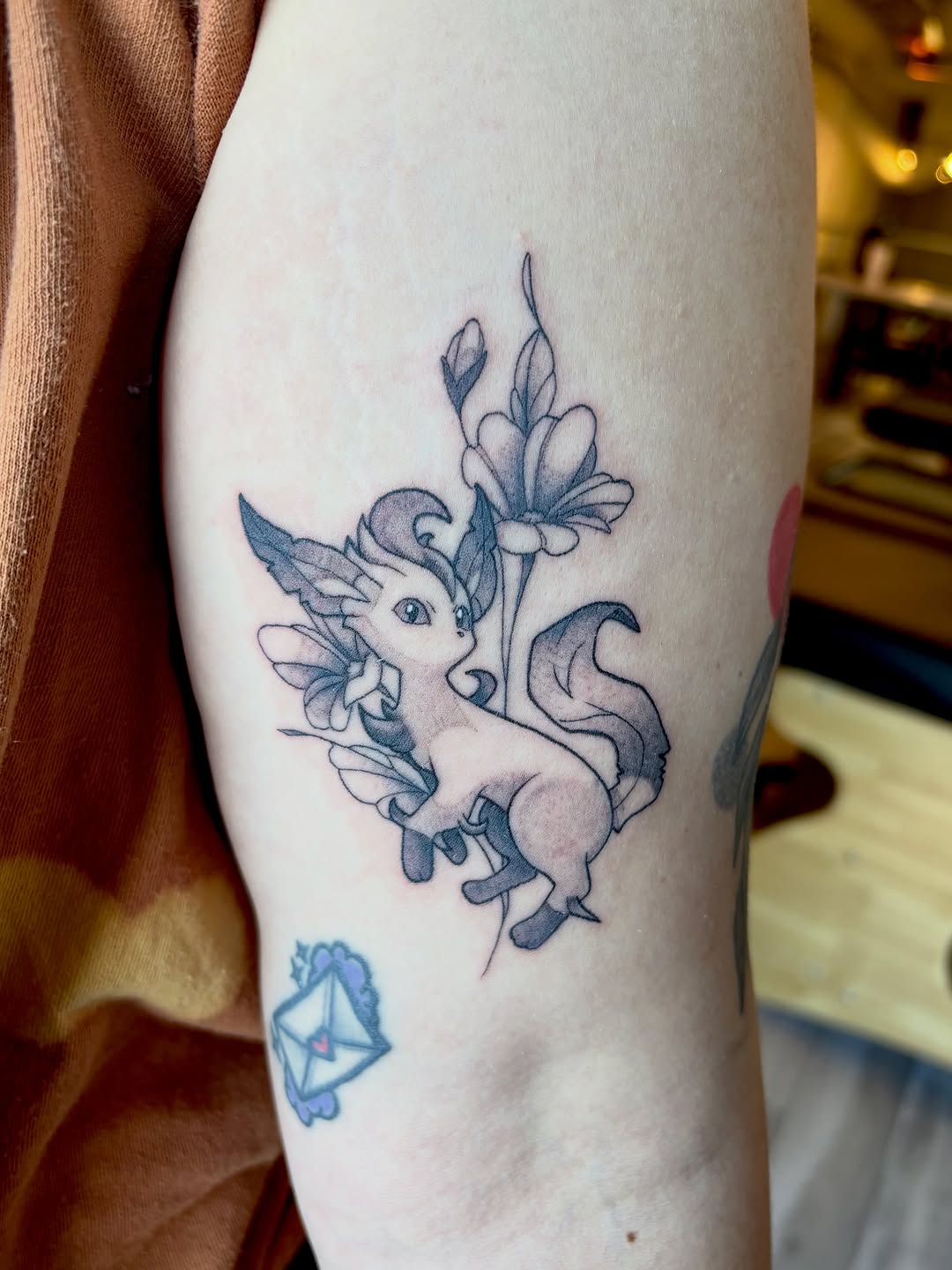 Pokemon character with flowers new school tattoo on the forearm by Bianca Cattapan