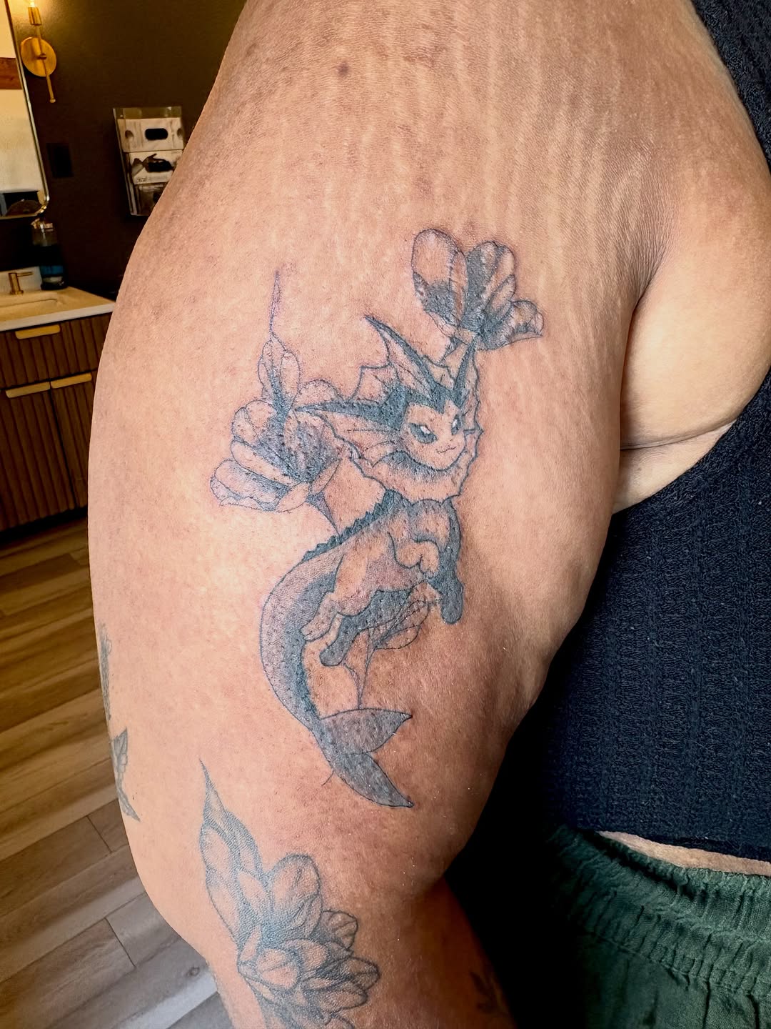 Vaporeon with flowers new school tattoo on the thigh by Bianca Cattapan