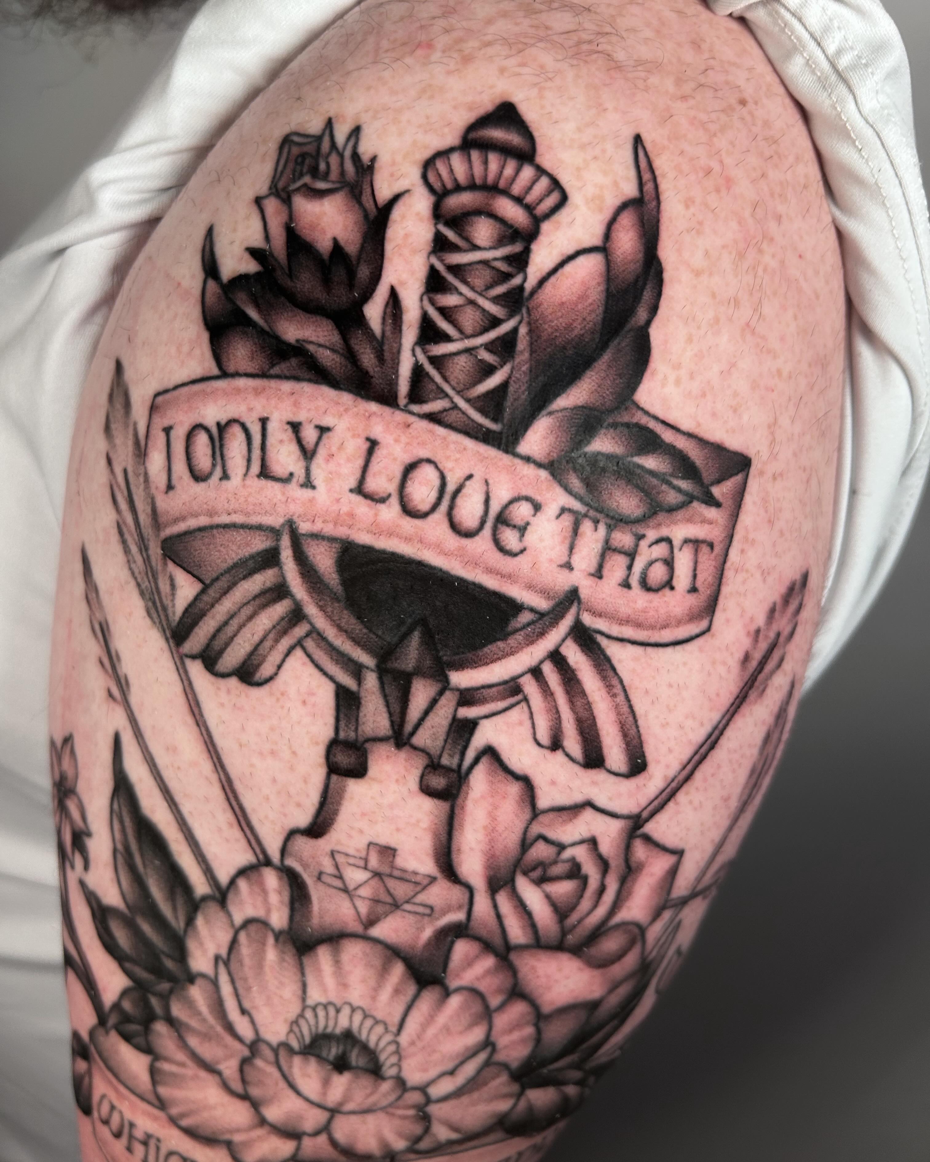 Flower arrangement with banner black and grey tattoo on the upper arm by Salt Lake City tattoo artist