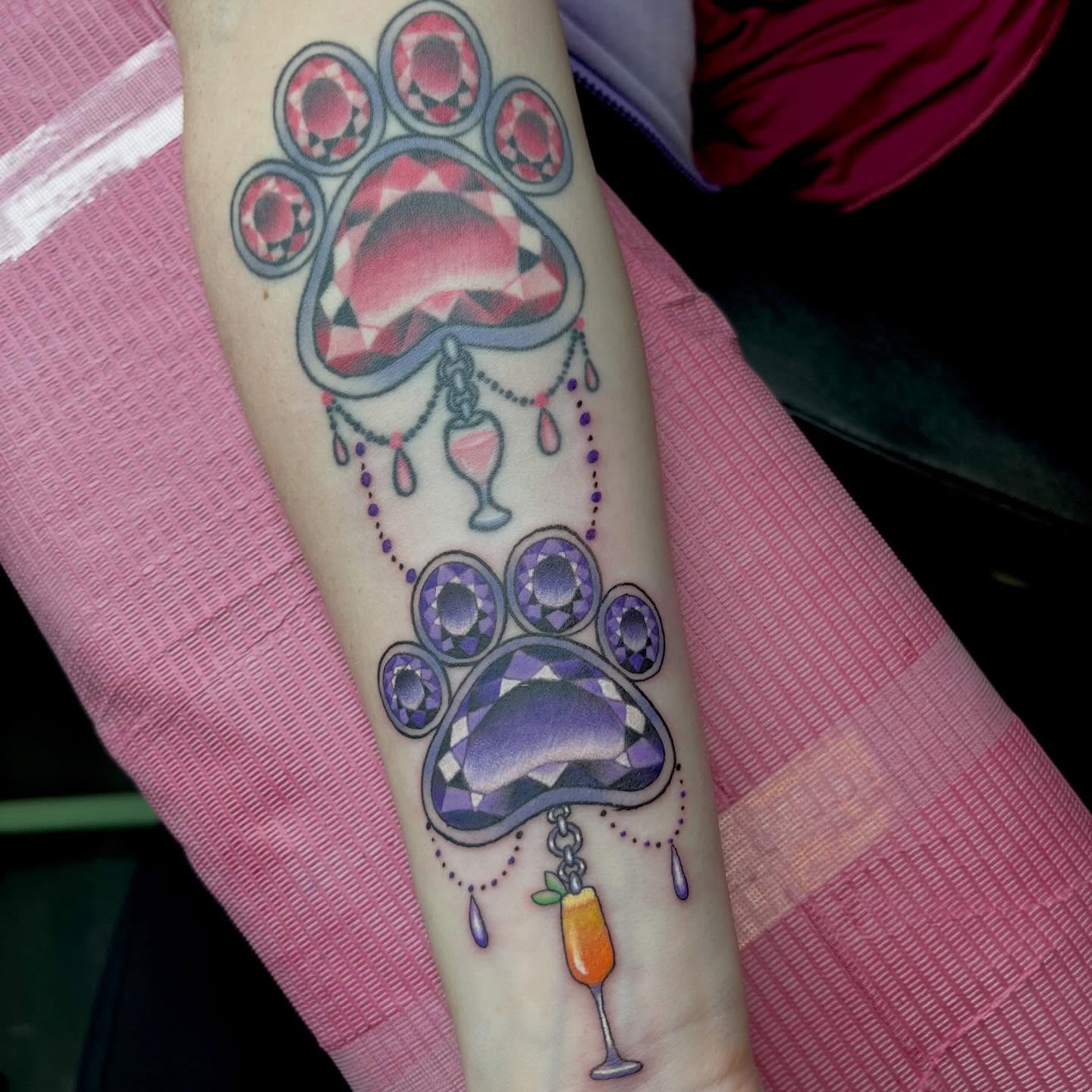 Paw prints geometric tattoo on the forearm by Ash Wheeler