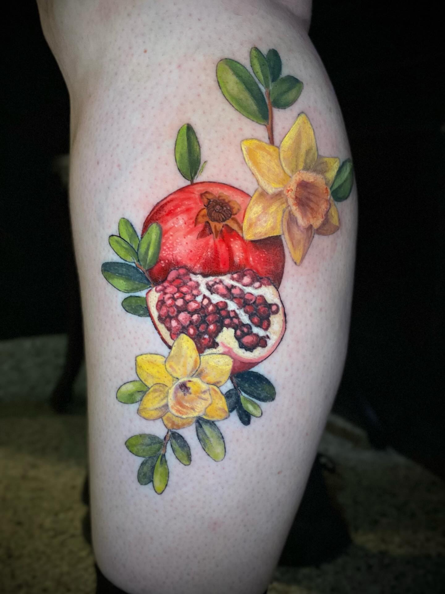 Pomegranate and daffodil realism tattoo on the forearm by Olivia Scott - Kansas Tattoo Artist
