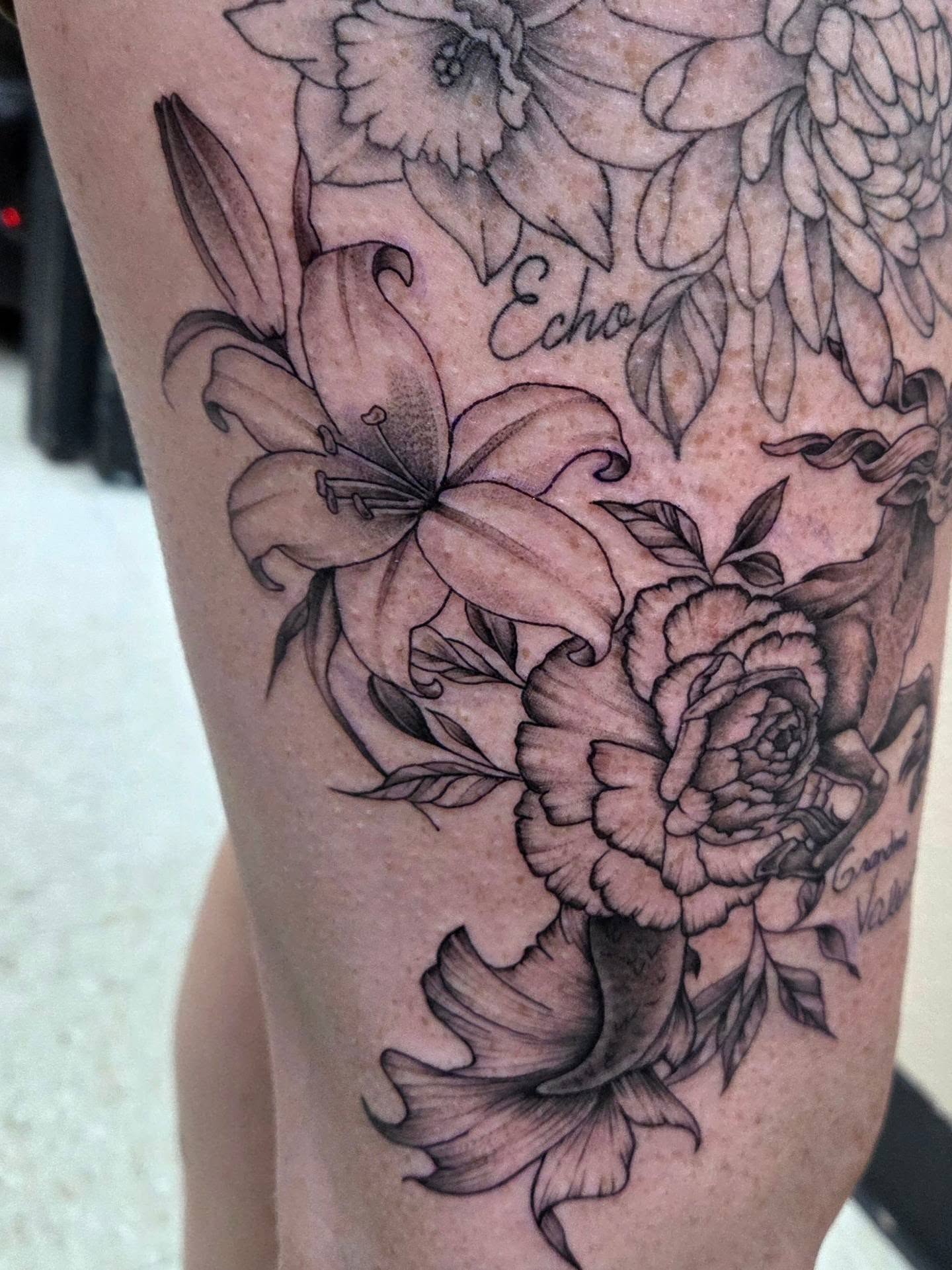 Lilies and roses black and grey tattoo on the forearm by Ashley