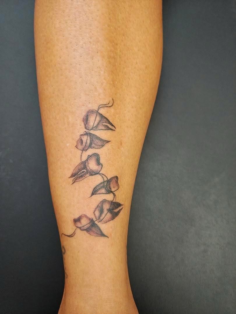 Calla lilies black and grey tattoo on the forearm by Sebastiana