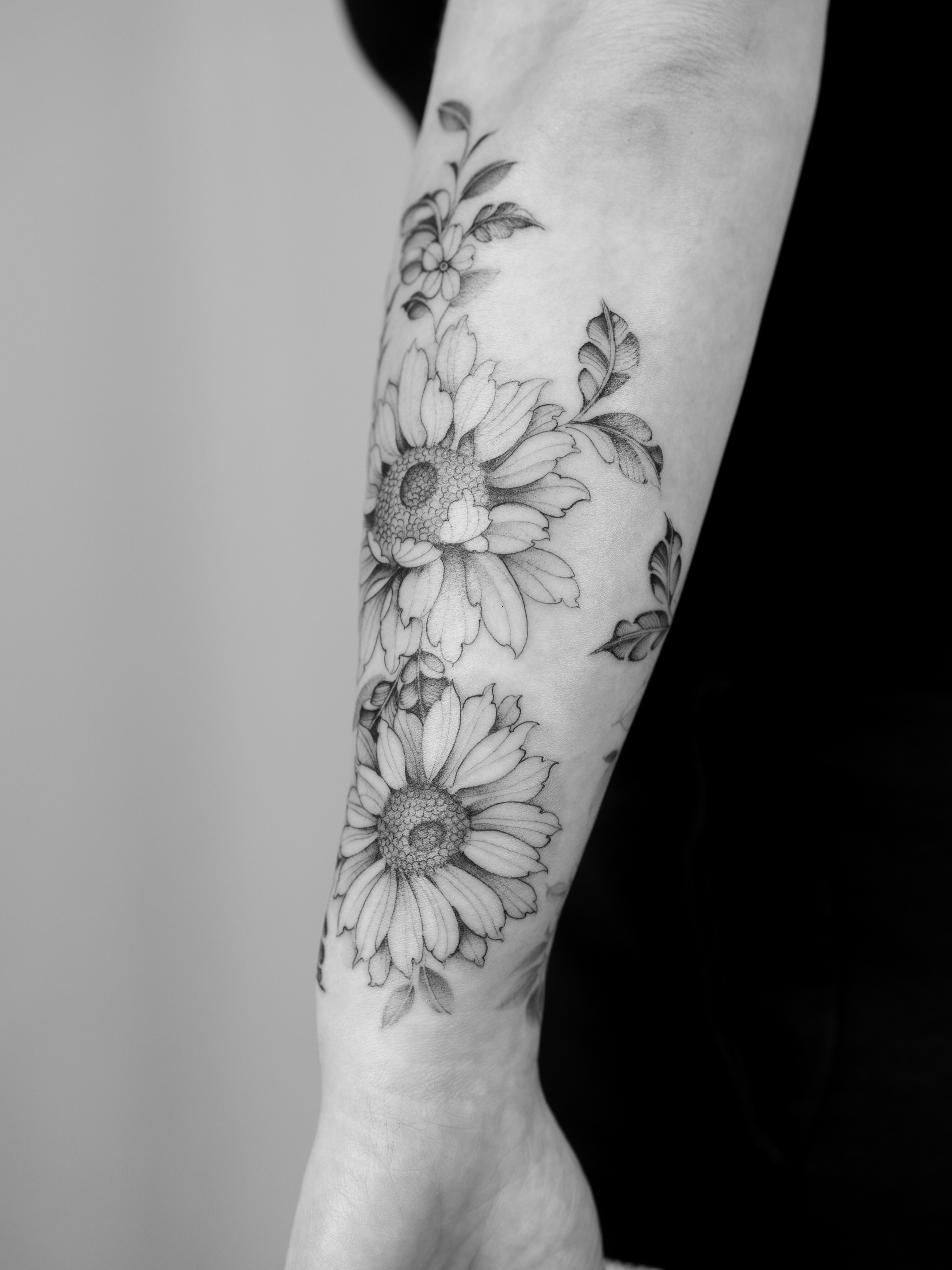 Sunflowers black and grey tattoo on the forearm by Leo Gao