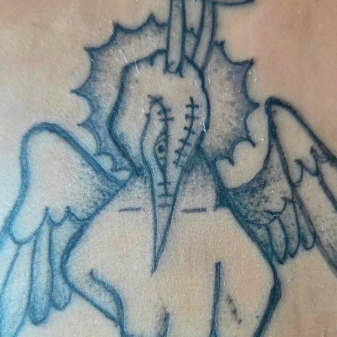 Winged creature with stitched face cyber sigilism tattoo on the chest by π«