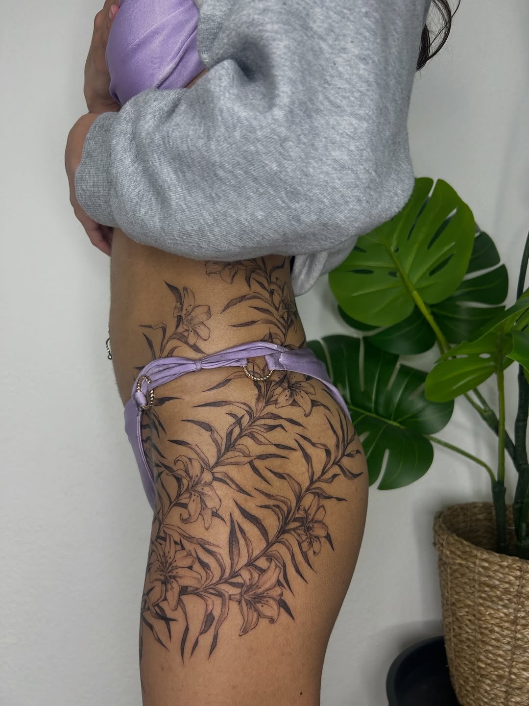 Floral vine fine line tattoo on the thigh by Miri