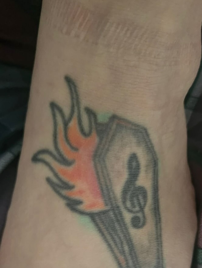 Flame and accordion American traditional tattoo on the forearm by Bre Alex