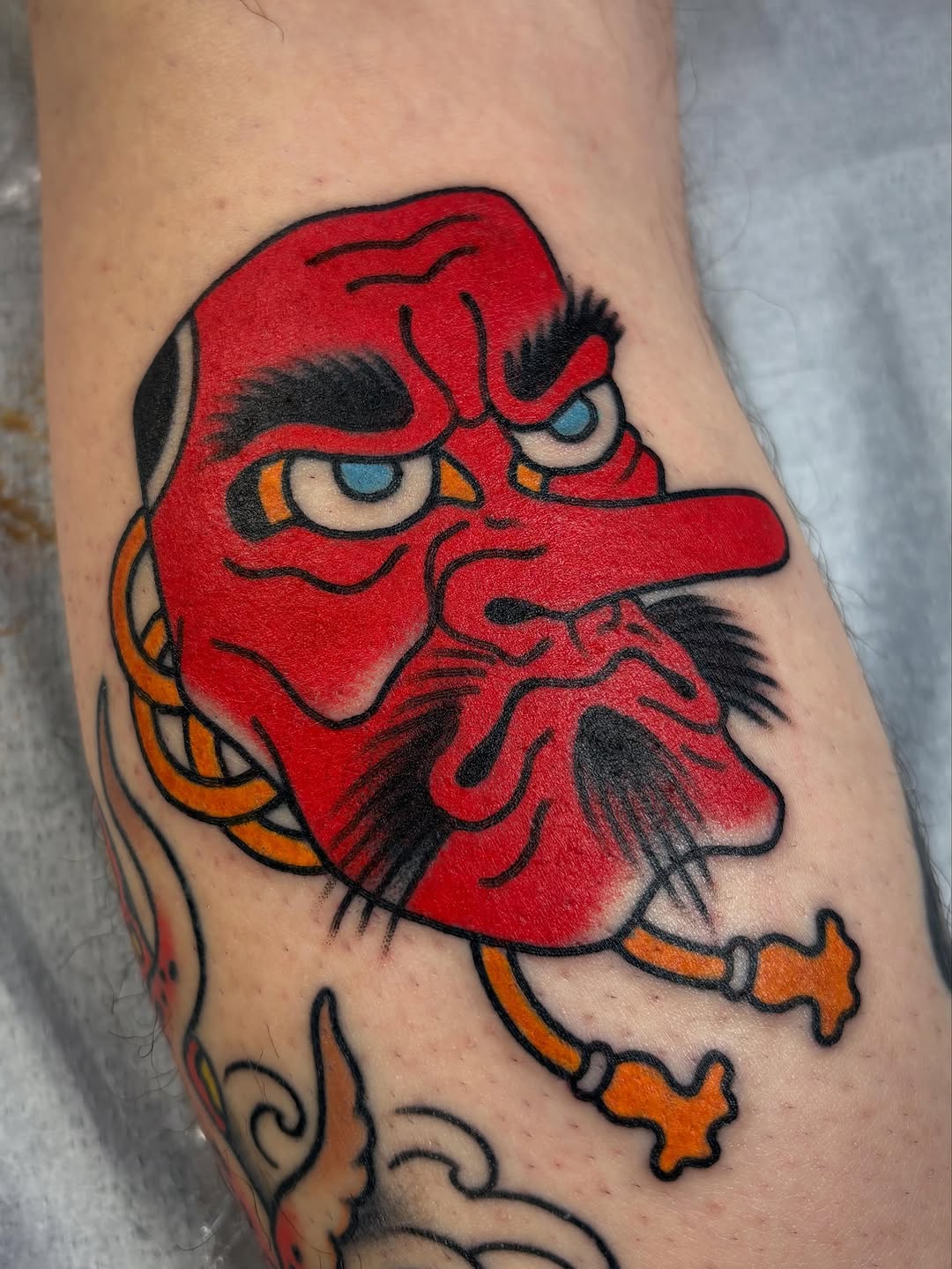 Tengu mask Japanese tattoo on the forearm by Tom Wenzell