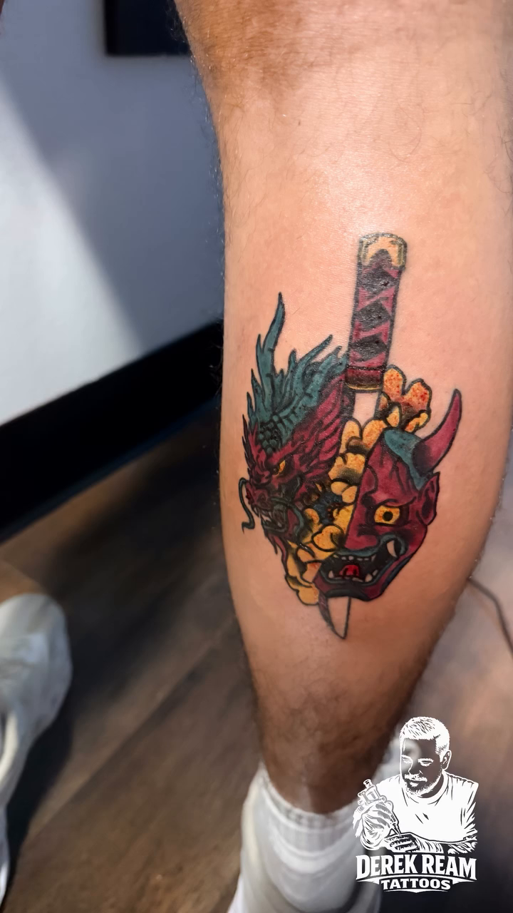Hannya mask with sword and flowers Japanese tattoo on the leg by Derek Ream