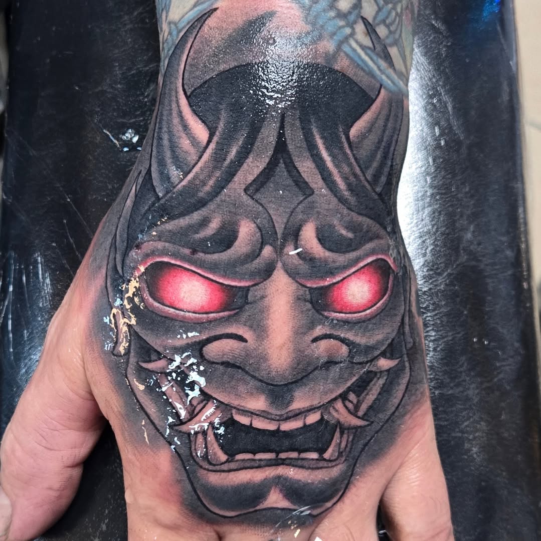 Demon mask dark realism tattoo on the hand by Jeff Stager