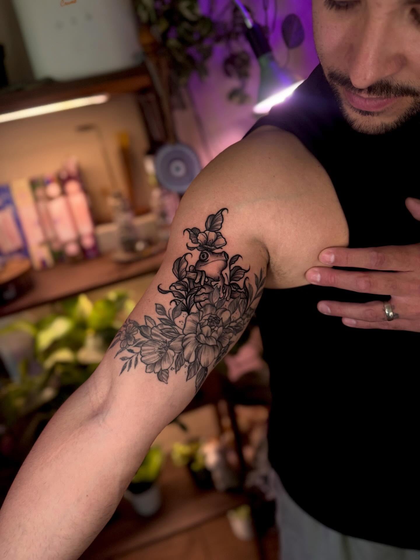 Floral bouquet black and grey tattoo on the upper arm by Angie Cotton