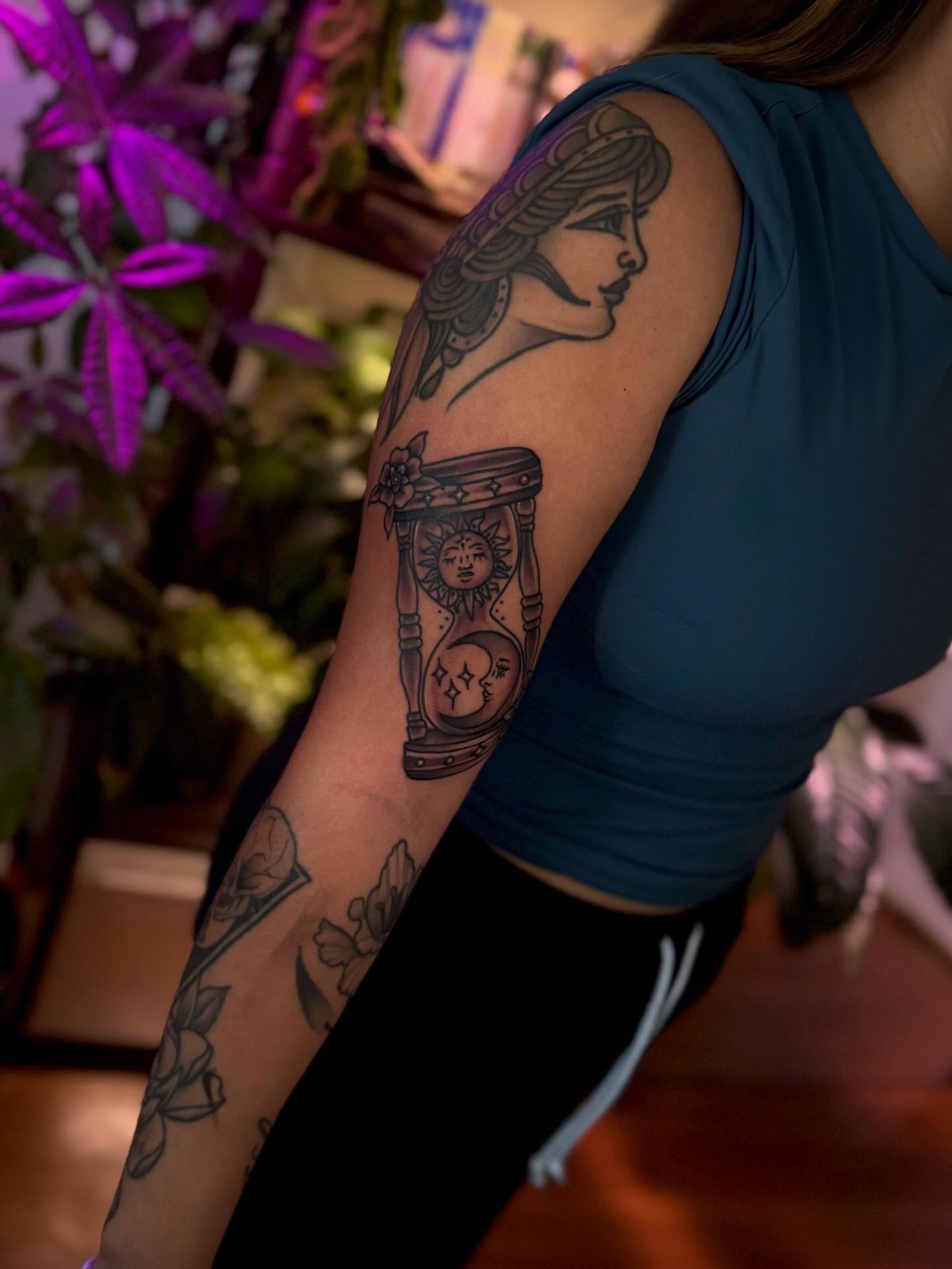 Woman with sun and moon American traditional tattoo on the forearm by Angie Cotton