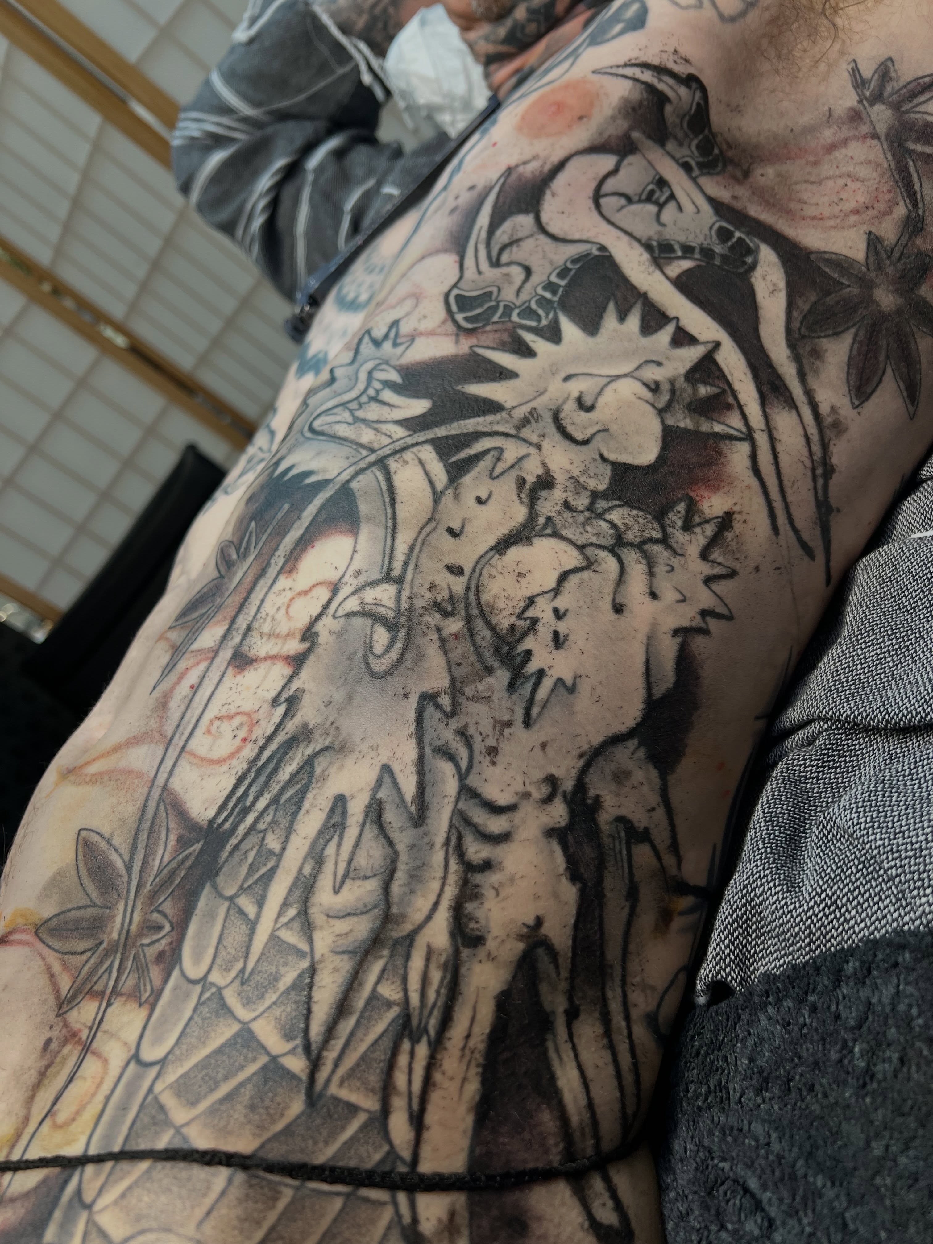 Dragon black and grey tattoo on the upper arm by James Fernella, San Francisco, California