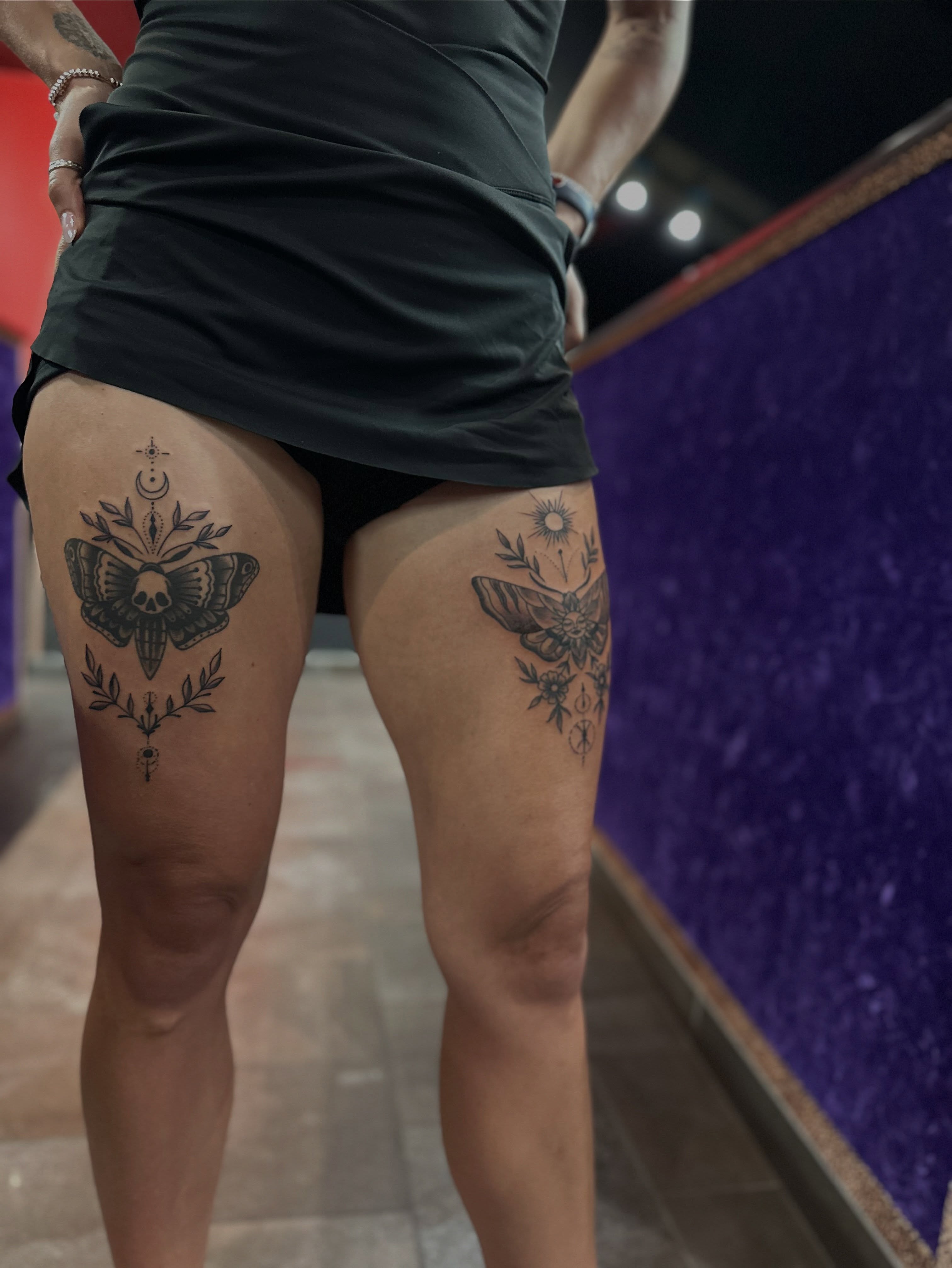 Butterfly and skull black and grey tattoo on the thigh by Walk-in American Traditional Tattoos Las