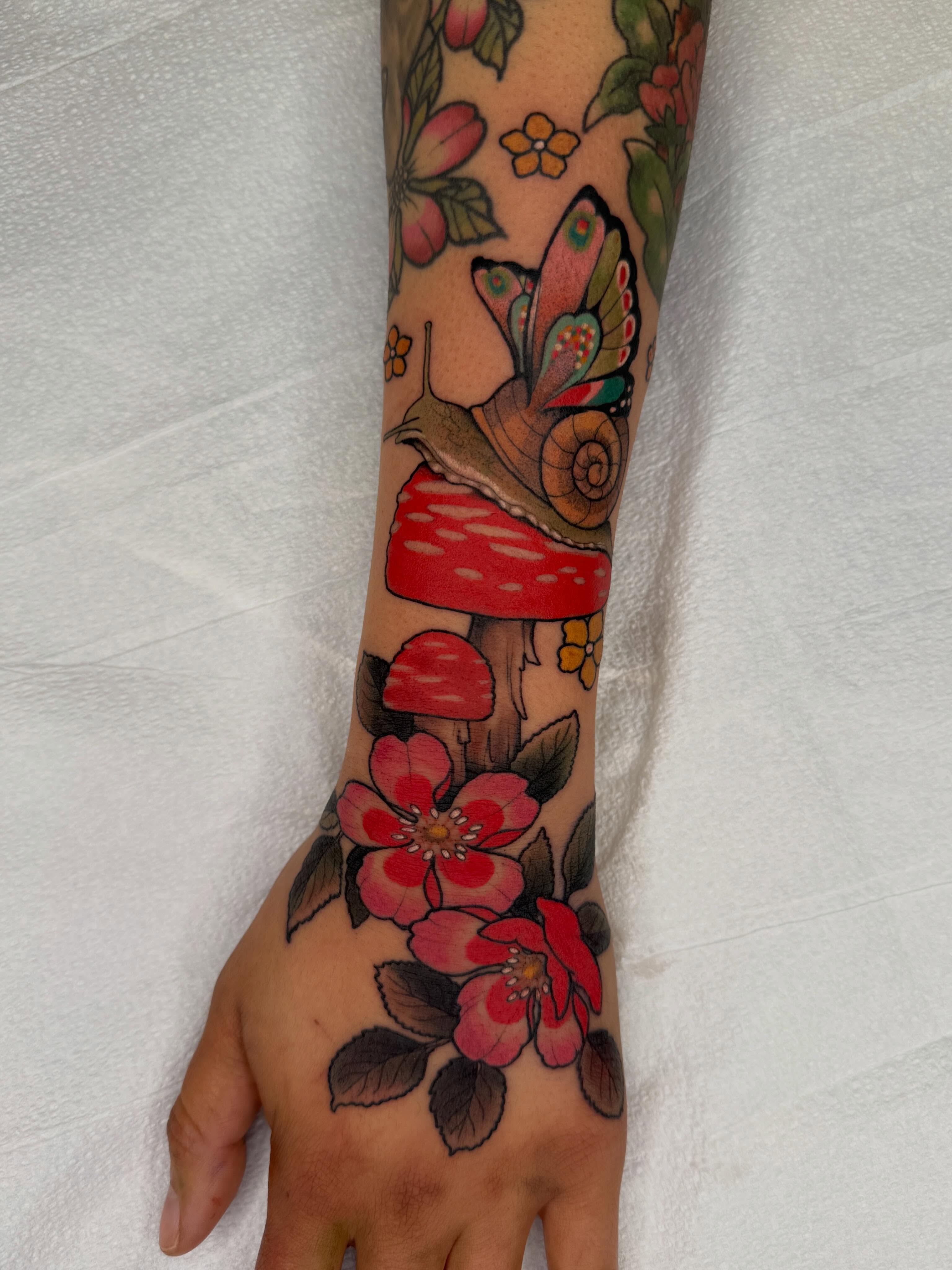 Flowers and butterfly American traditional tattoo on the forearm by Samantha Compasso Ford