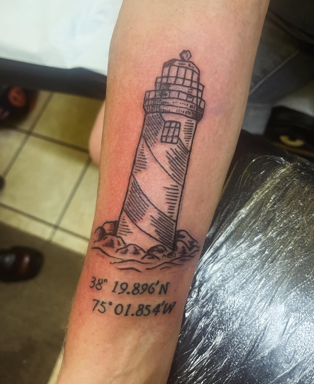 Lighthouse black and grey tattoo on the forearm by Rafaela Lopez
