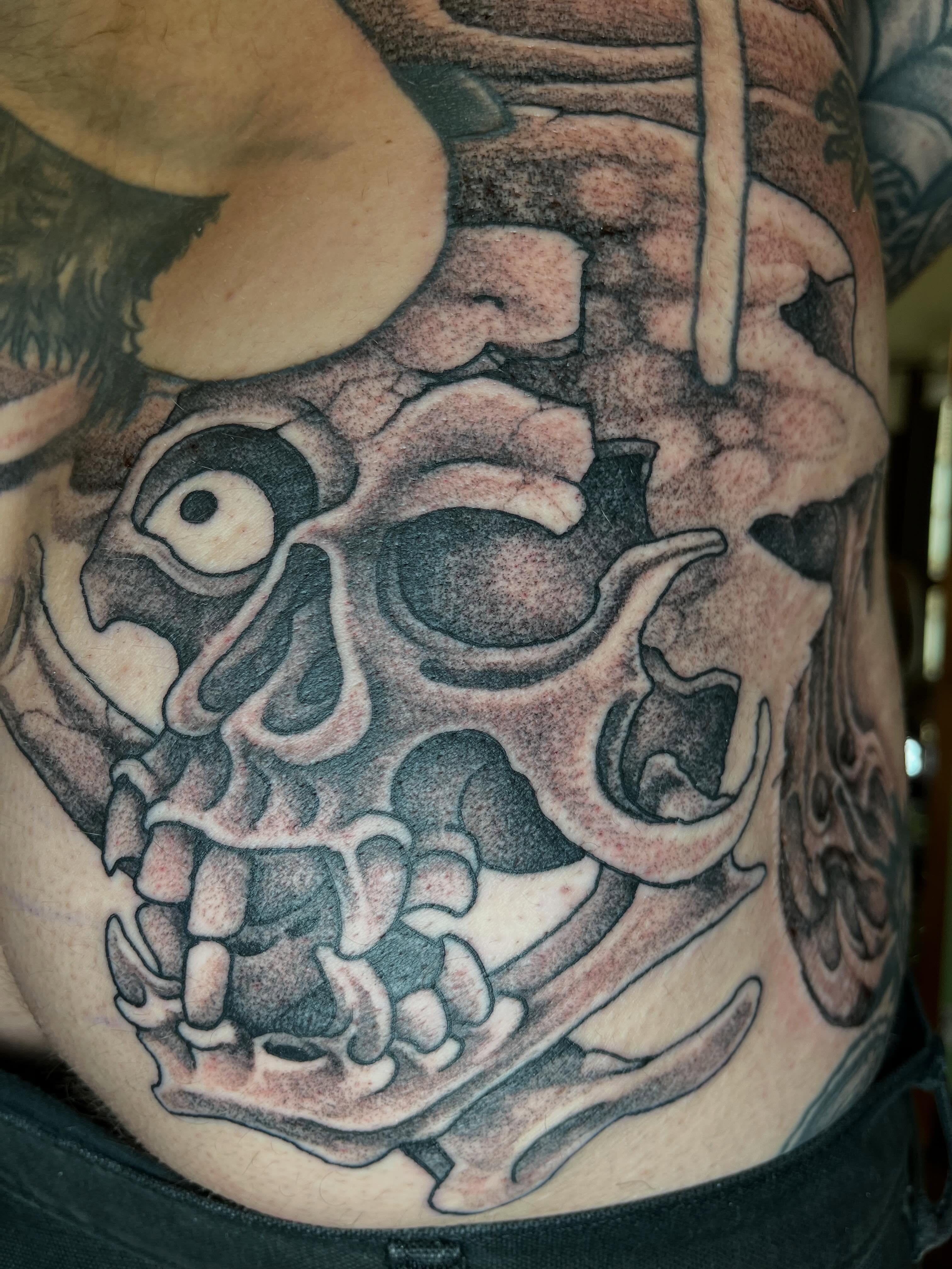 Skull black and grey tattoo on the chest by Chris Kline