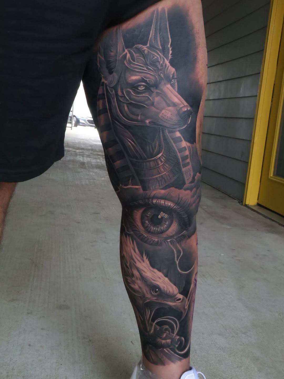 Anubis, eye, and eagle surrealism tattoo on the forearm by Angels tattoo