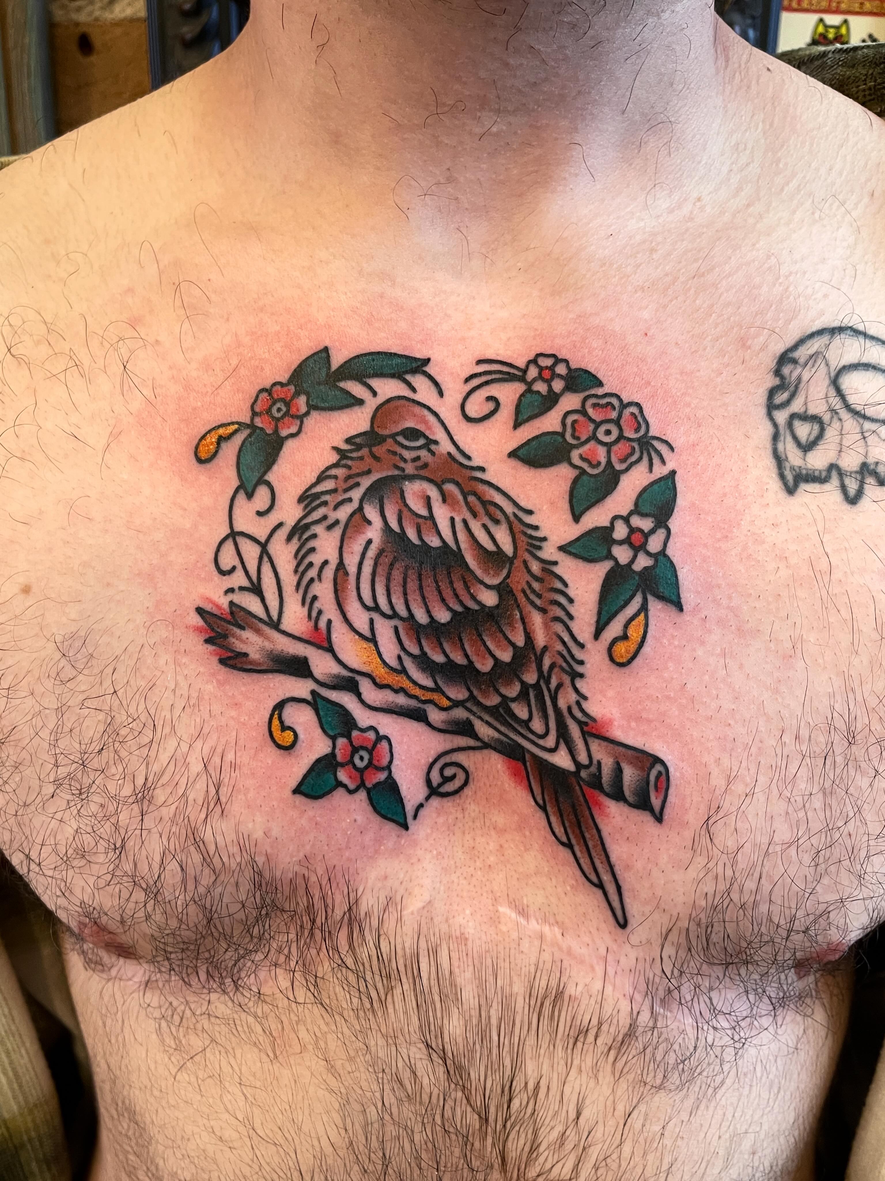 Bird and floral American traditional tattoo on the chest by Spencer Reisbeck