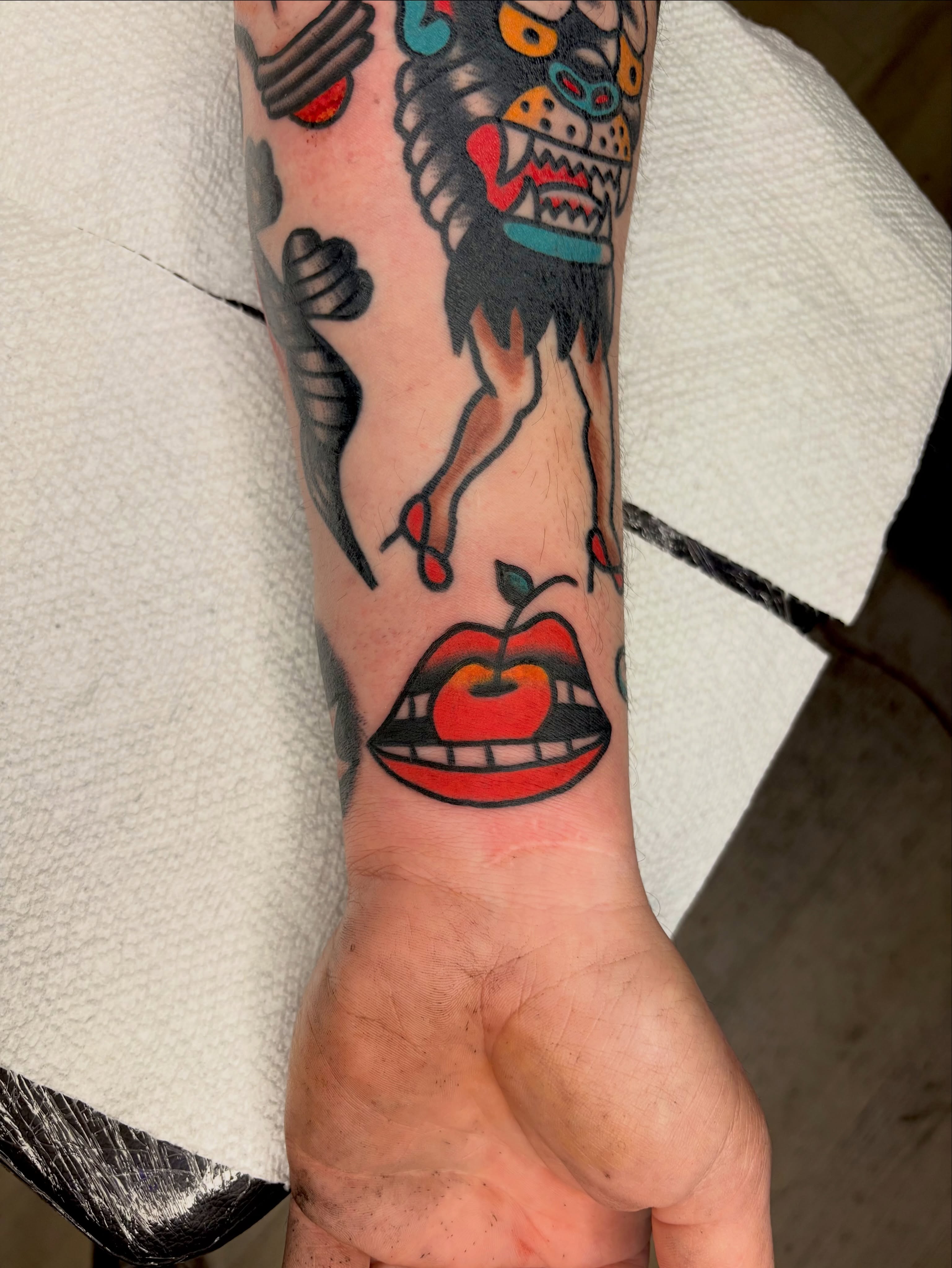 Apple and lips American traditional tattoo on the forearm by Braedon 🎱