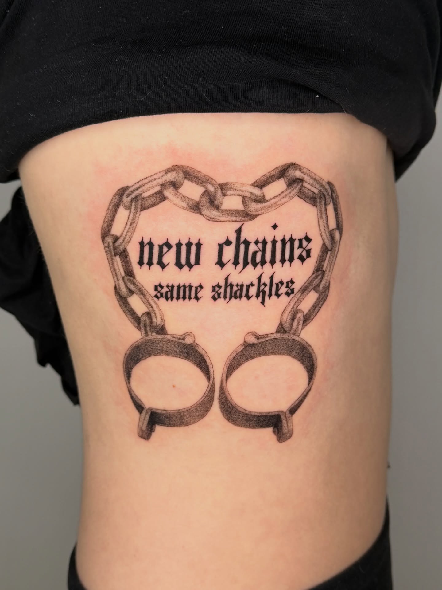Chains and handcuffs black and grey tattoo on the thigh by Jerm Lewis