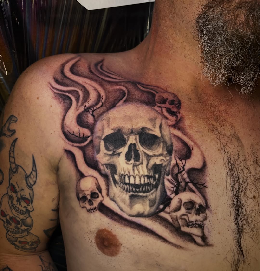 Skulls and smoke realism tattoo on the chest by Haley Byers